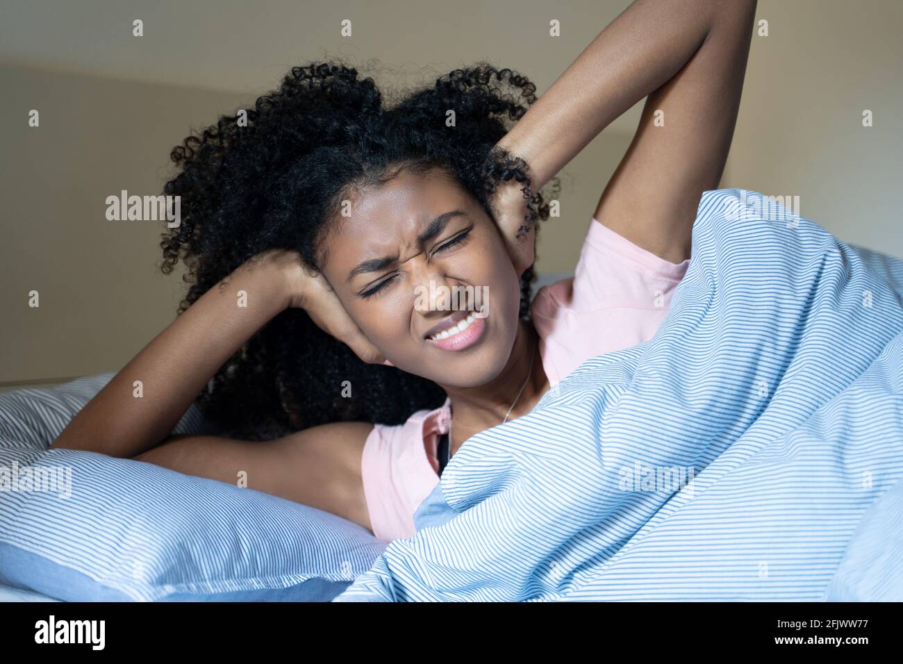 Black woman cannot sleep because of noisy neighbour Stock Photo