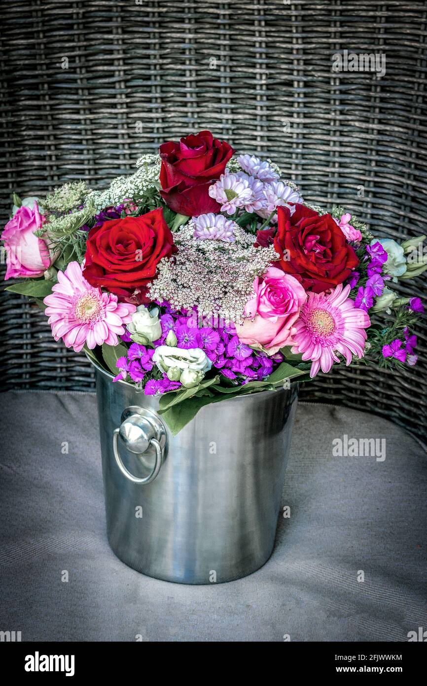 Beautiful red and pinkroses  flower bouquet arranged in a champagne bucket Stock Photo
