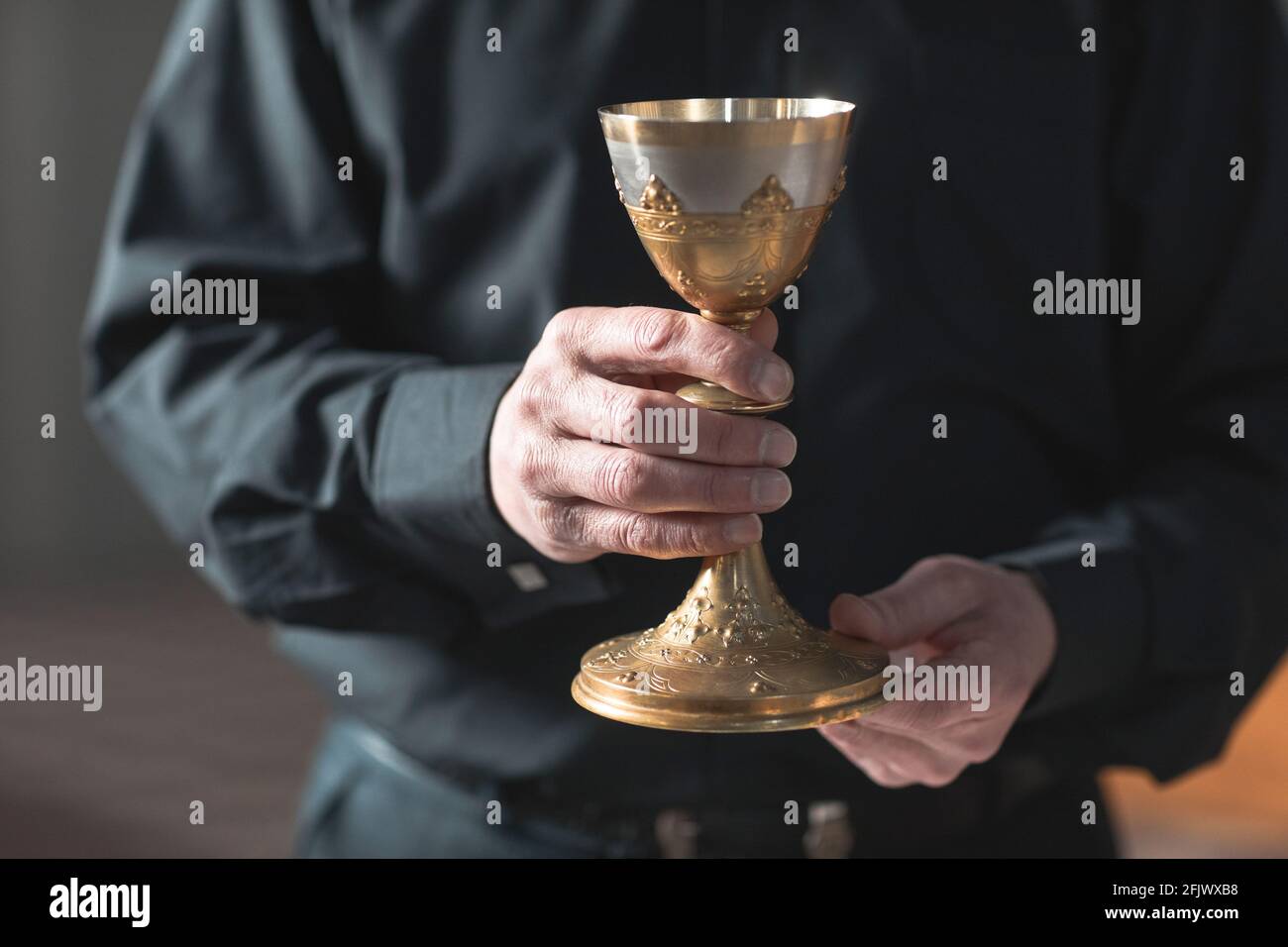 Close-up of senior priest holding the cup in the church Stock Photo