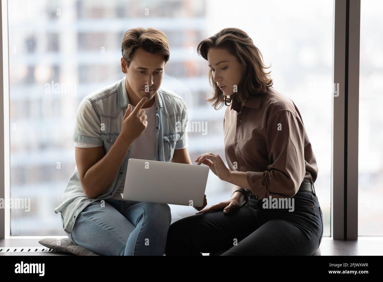 Pensive businesspeople think working on laptop in office Stock Photo