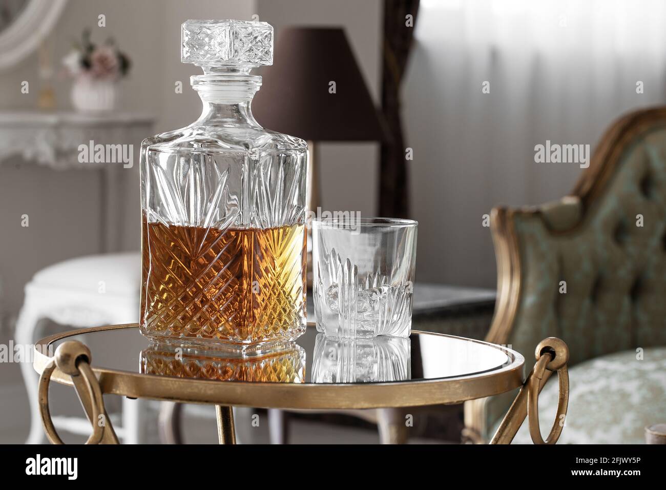 Whisky glass decanter hall-full with whisky liquor and an empty glass of  whiskey with on glass table in cozy hotel inerior Stock Photo - Alamy