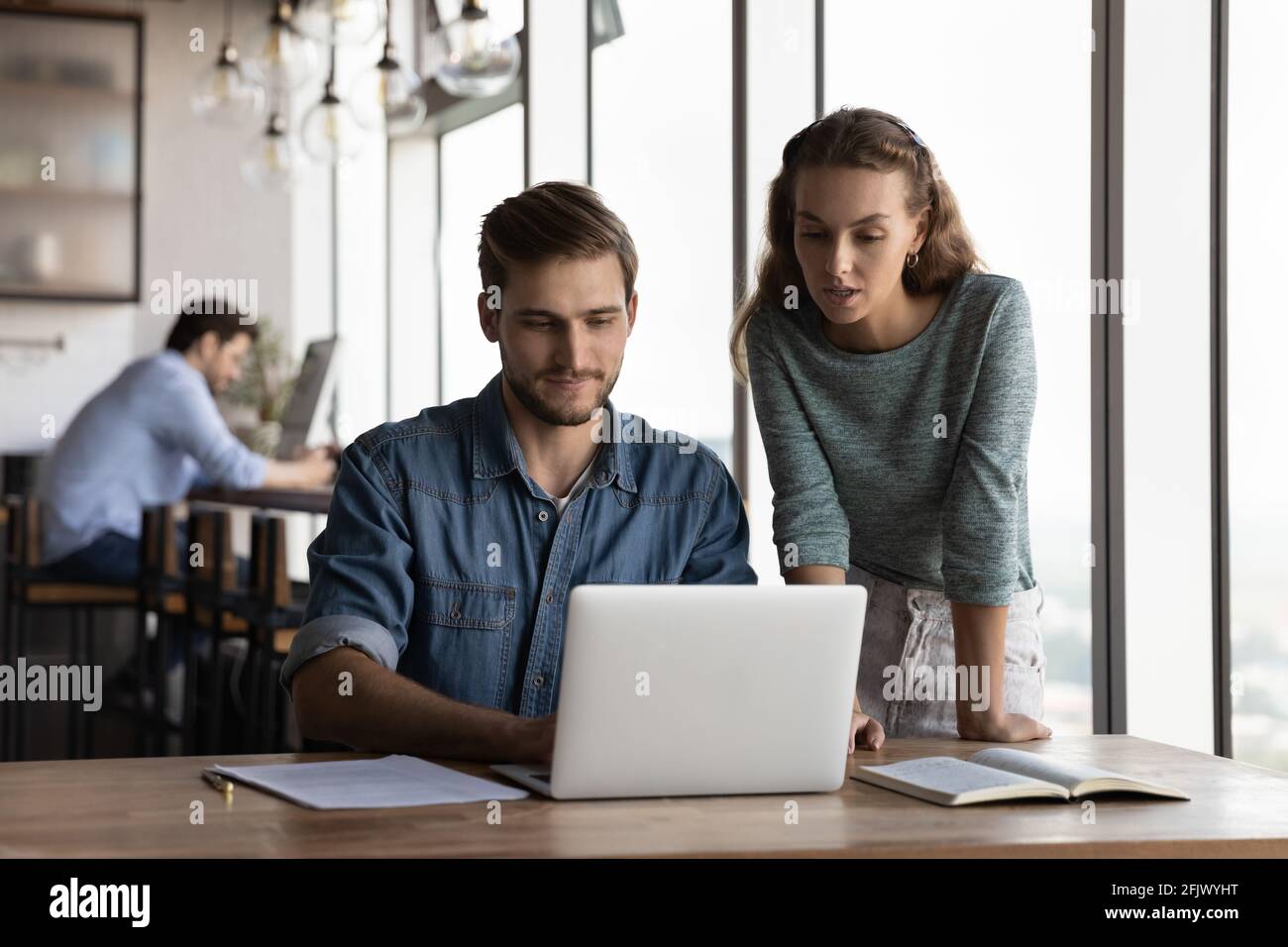 Young employees cooperate using laptop in office Stock Photo