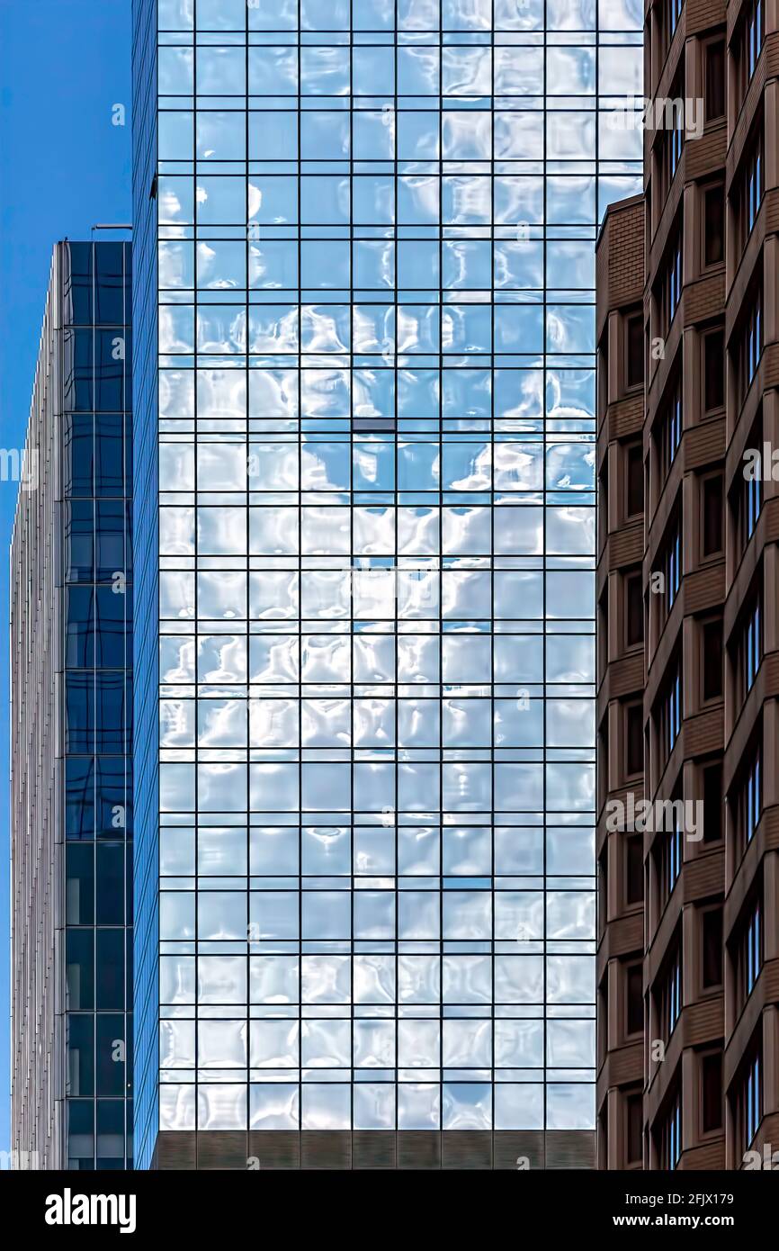 Glass facade of New York City skyscraper mirrors its surroundings. Stock Photo