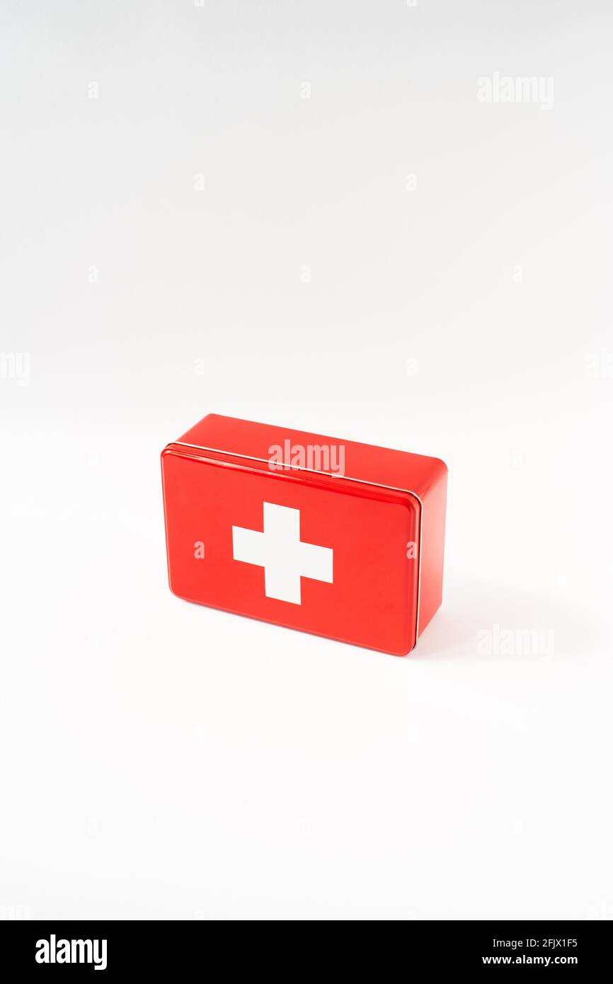 Red simplistic first aid box, white background, high key, vertical format Stock Photo