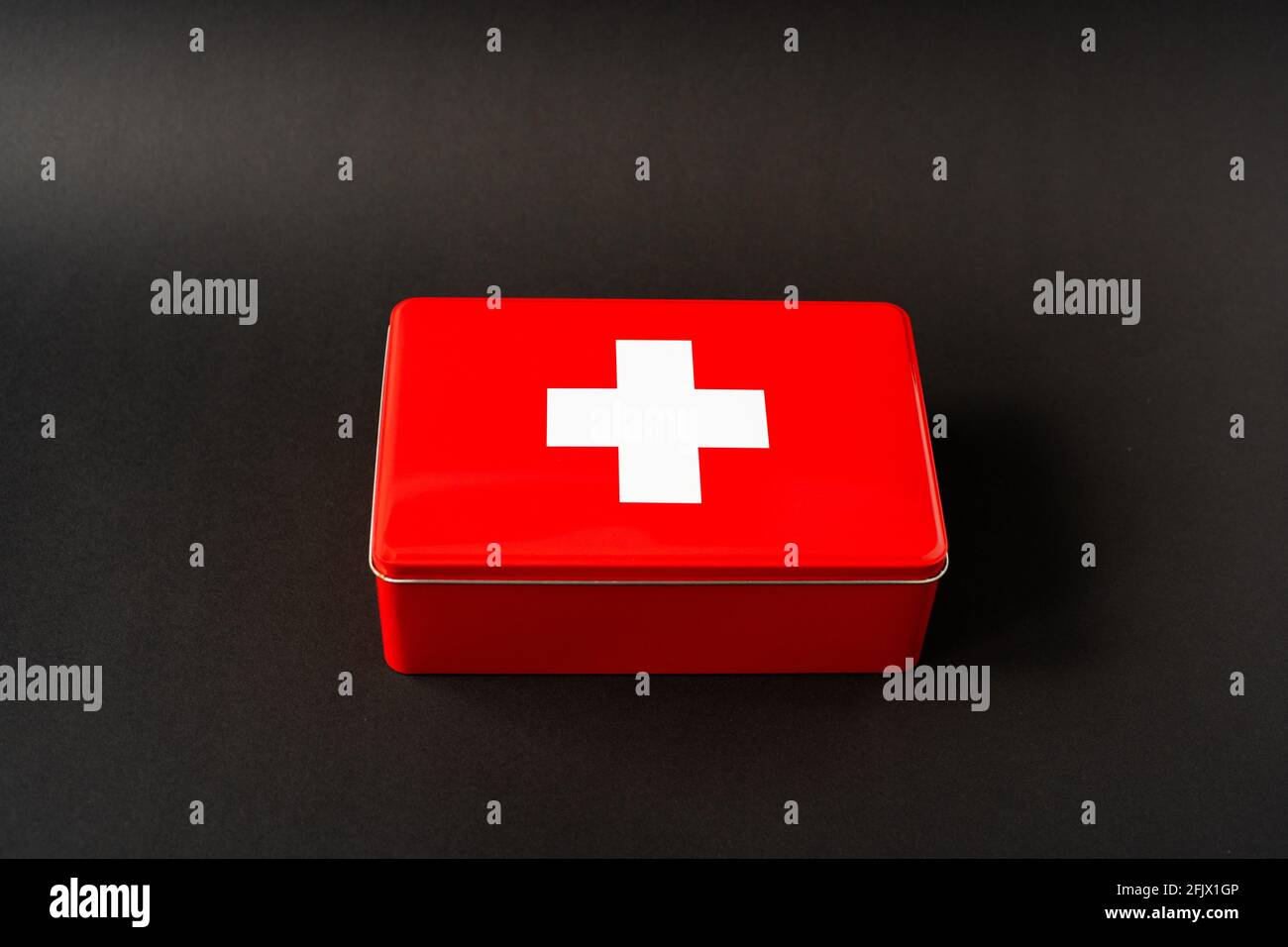 Red simplistic first aid box, black background with light gradient Stock Photo