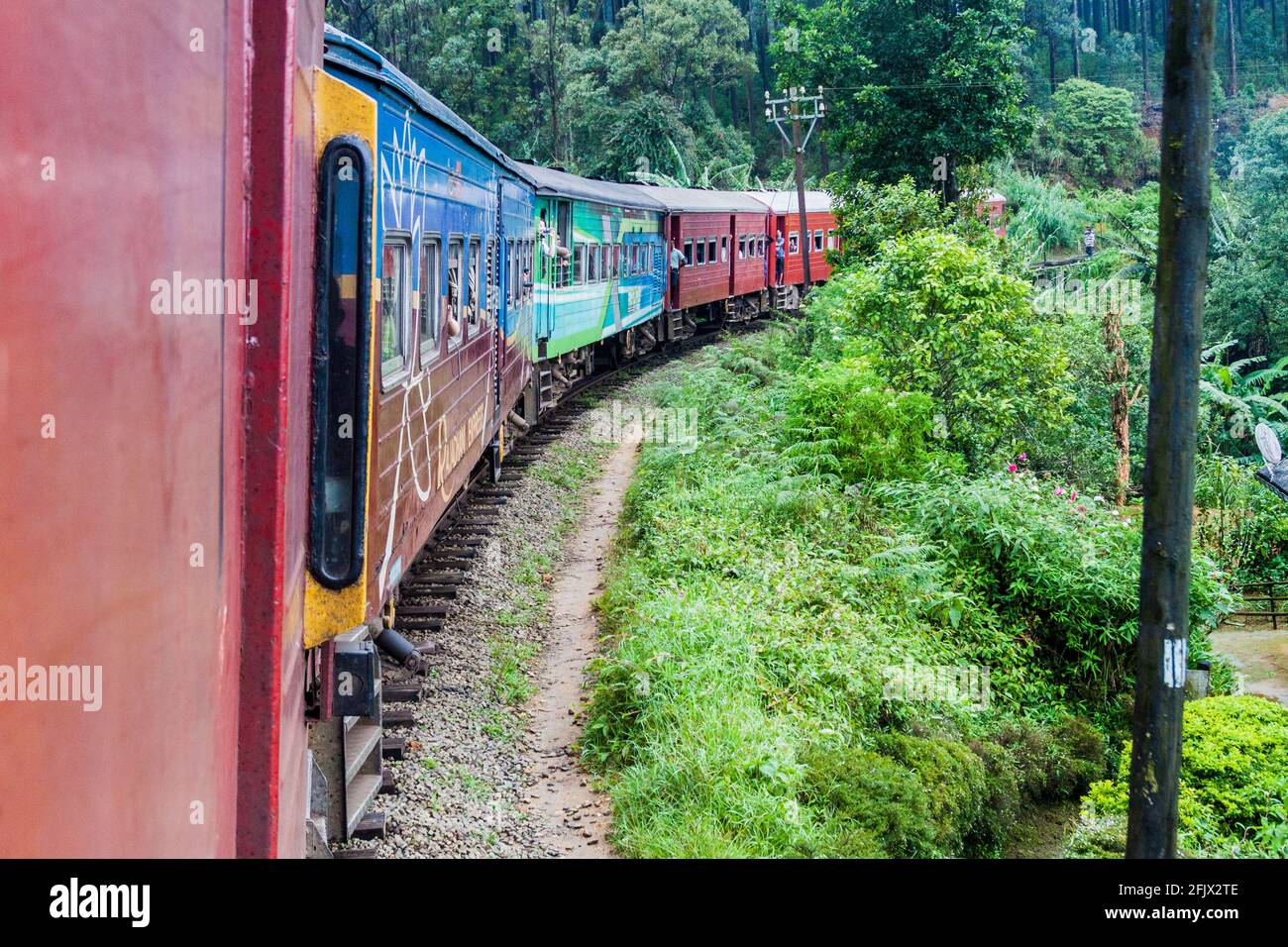 NANU OYA, SRI LANKA - JULY 16, 2016: Local train rides through a rural landscape near Nanu Oya village, Sri Lanka Stock Photo