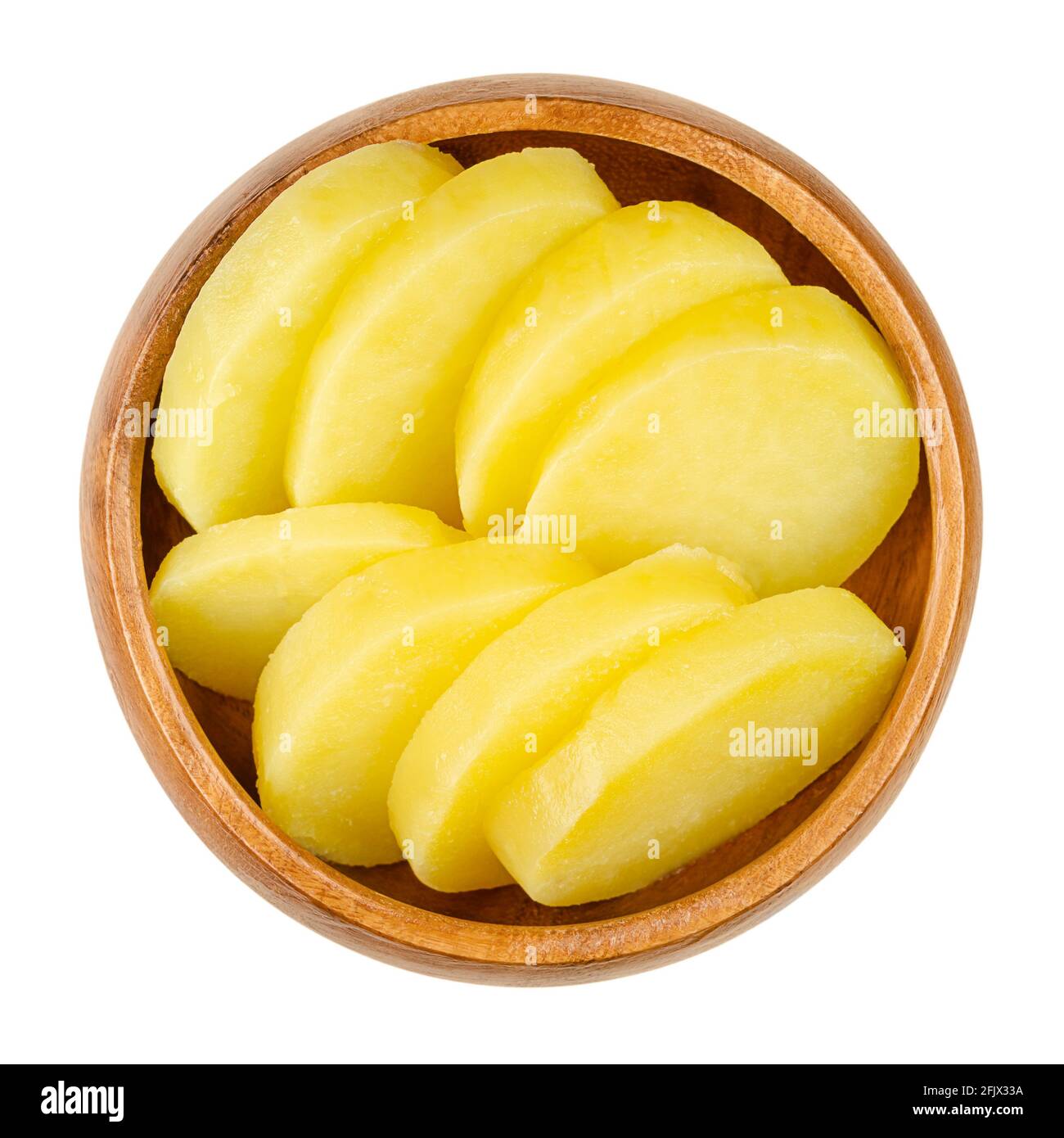 Cooked and sliced potatoes, in a wooden bowl. Boiled and peeled waxy potatoes, cut into thick slices. A side dish or for a salad. Close-up, from above Stock Photo