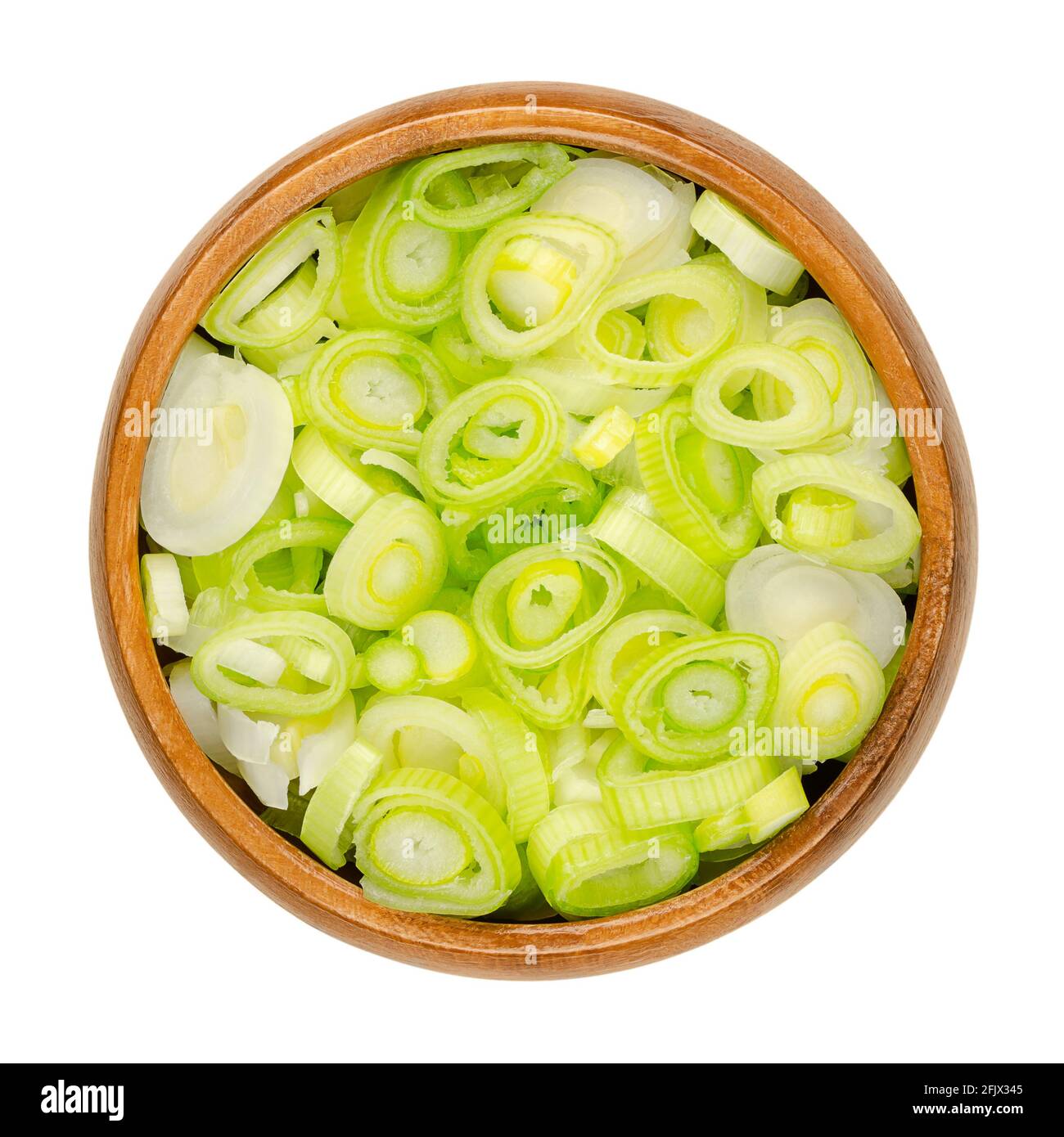 Sliced fresh scallions, in a wooden bowl. Chopped bulbs of green onions, also spring onions or sibies. Vegetable with mild onion taste. Close-up. Stock Photo