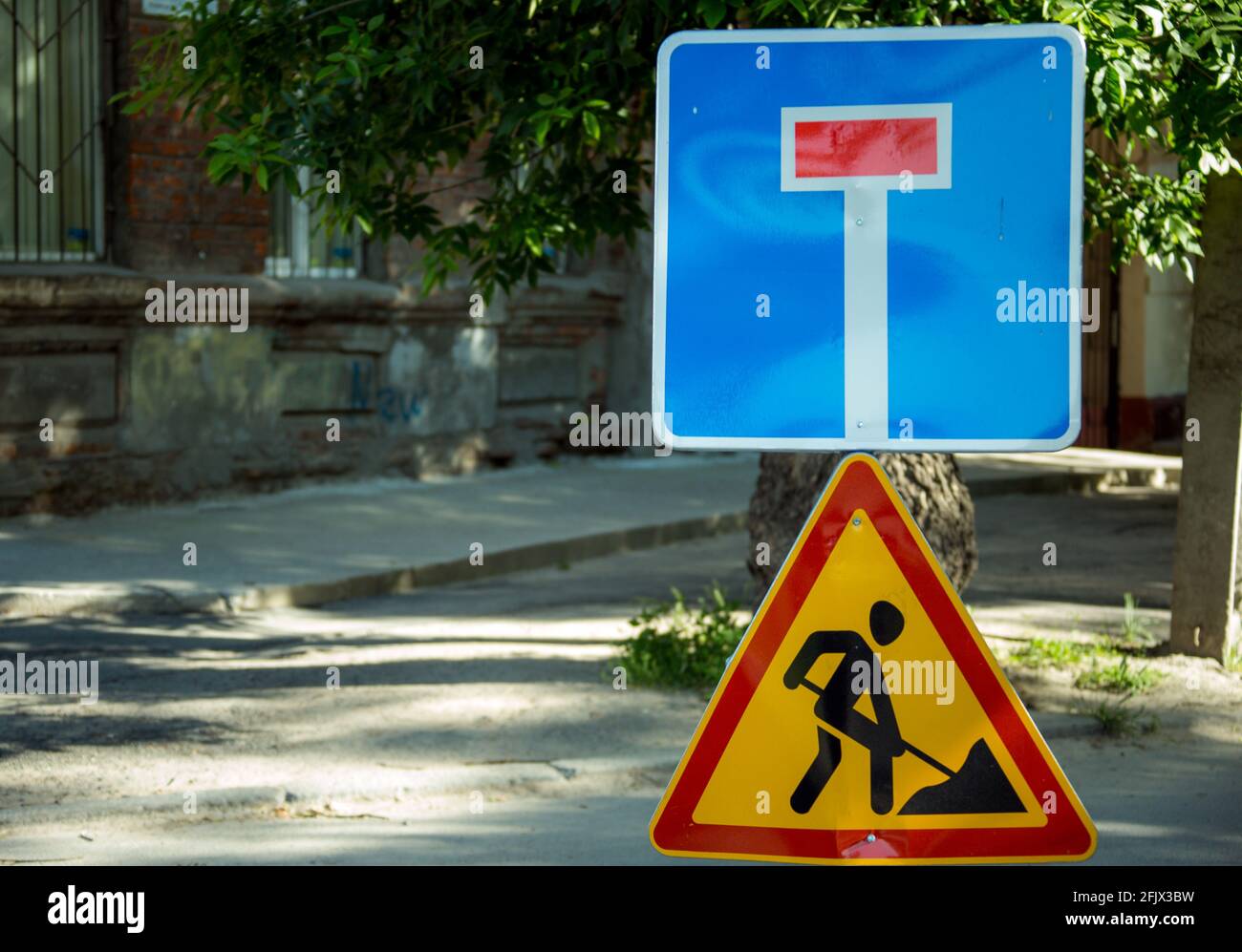 Road sign on the road. Work repair sign. Repair of roads. To make asphalt. Road Ahead Closed and Diversion signs in a street during construction work. Stock Photo