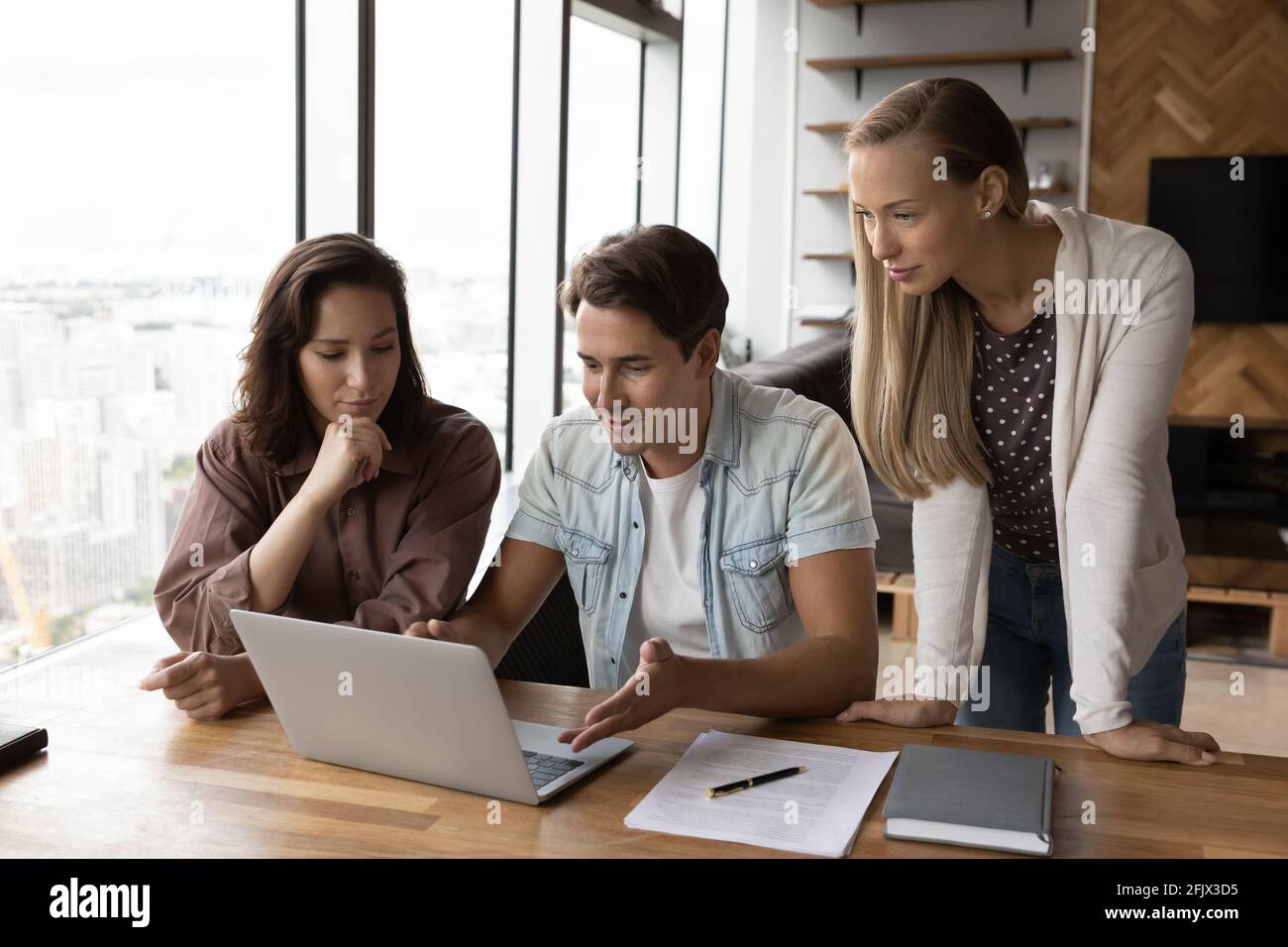 Diverse colleagues work together on laptop in office Stock Photo - Alamy