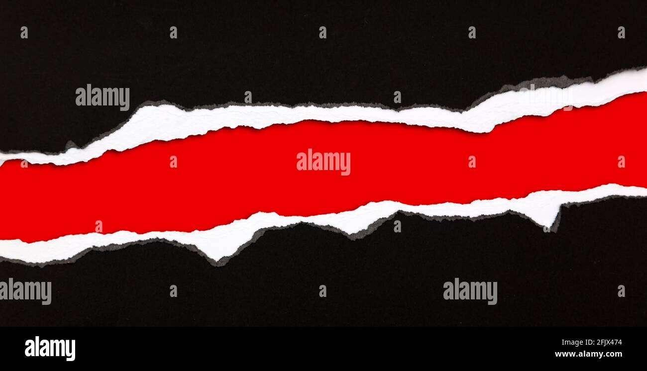 Hole ripped in paper on red background Stock Photo