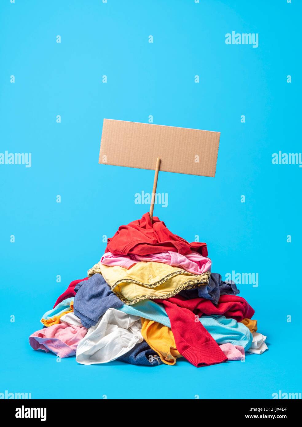 Pile of used clothes with a cardboard sign prepared for a text