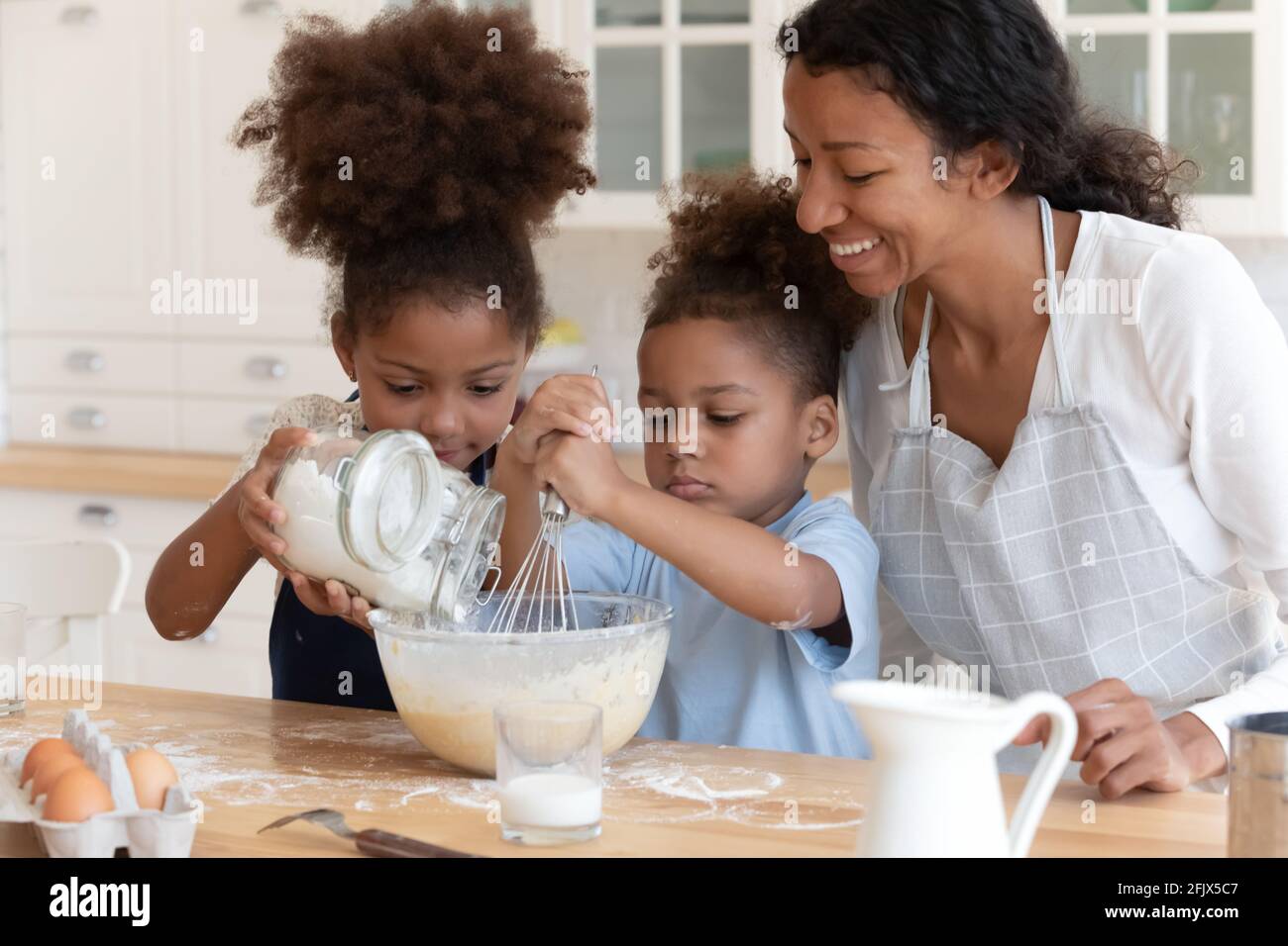 Happy mom teaching two preschooler kids to bake pie Stock Photo Alamy