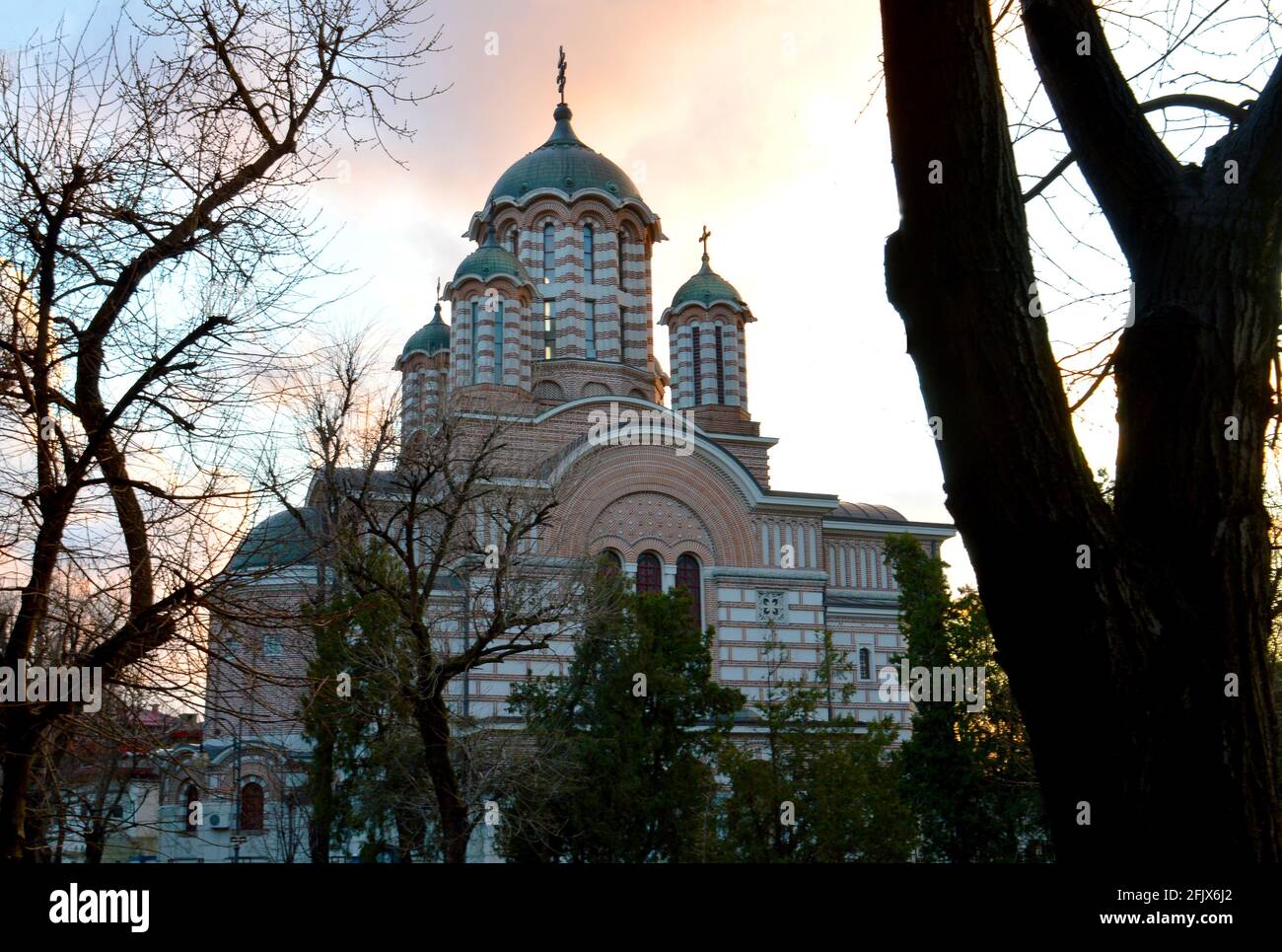 Biserica Sfântul Elefterie (Church of St Eleftherus), a Romanian orthodox church in Bucharest seen through the threes in evening light Stock Photo