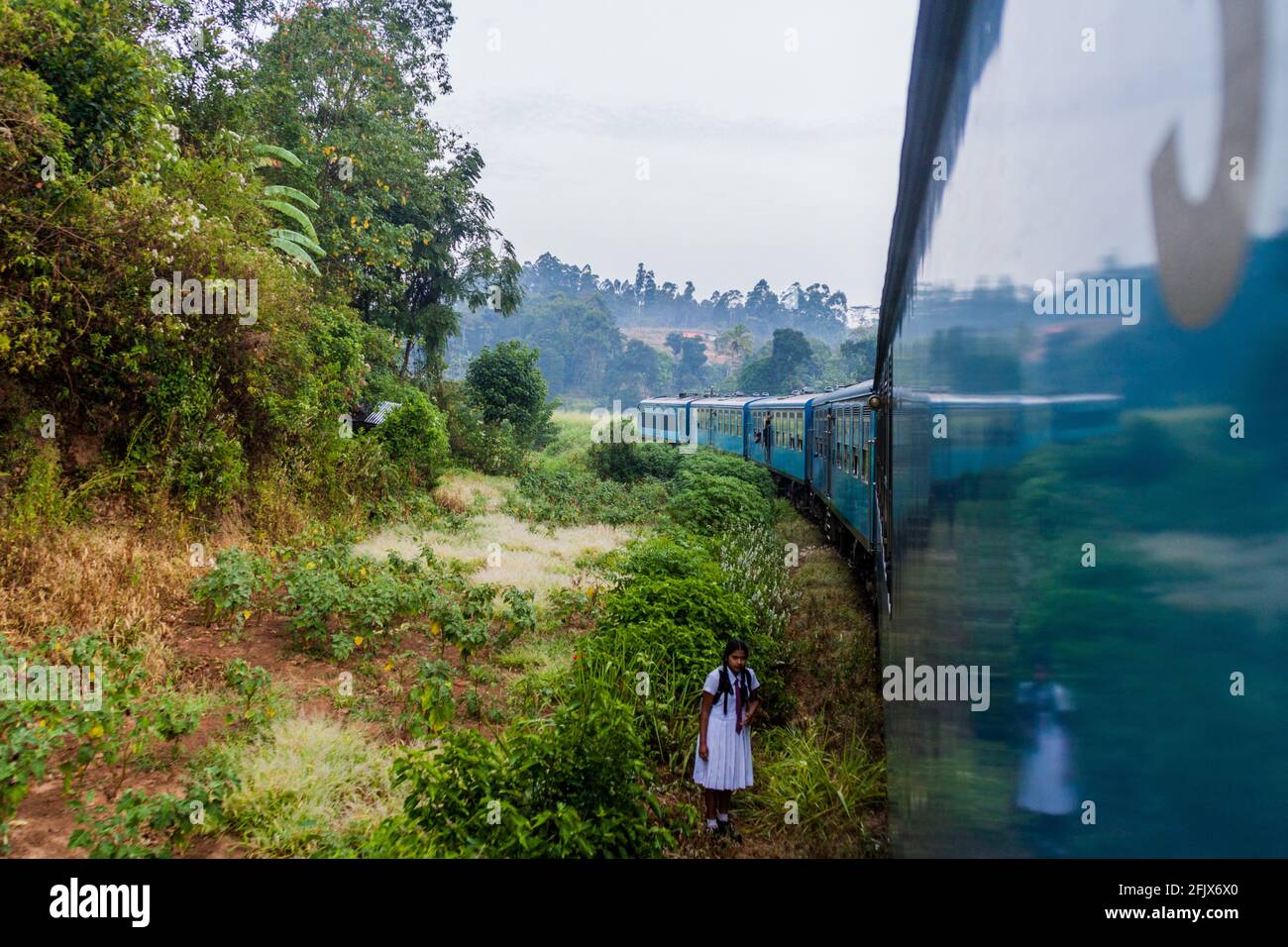ELLA, SRI LANKA - JULY 15, 2016: Girl in a school uniform walk along railway tracks near Ella, Sri Lanka Stock Photo