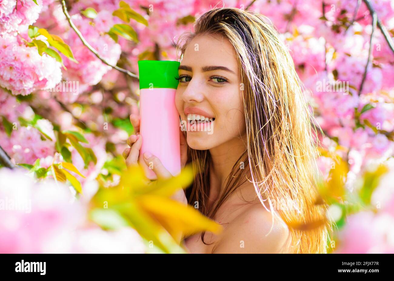 Beautiful woman with shampoo, balsam or conditioner. Smiling girl with
