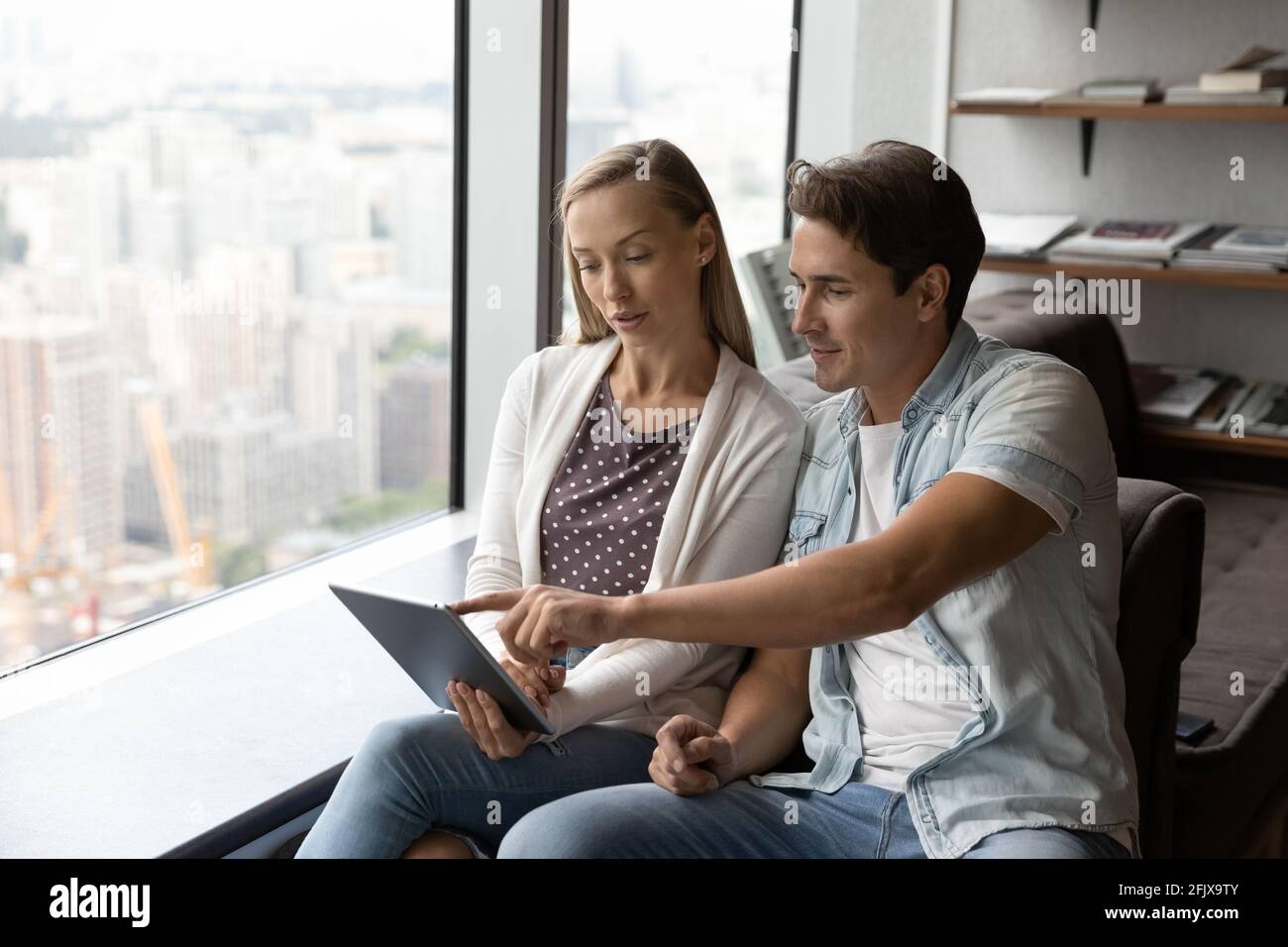 Diverse employees work on tablet discussing ideas Stock Photo