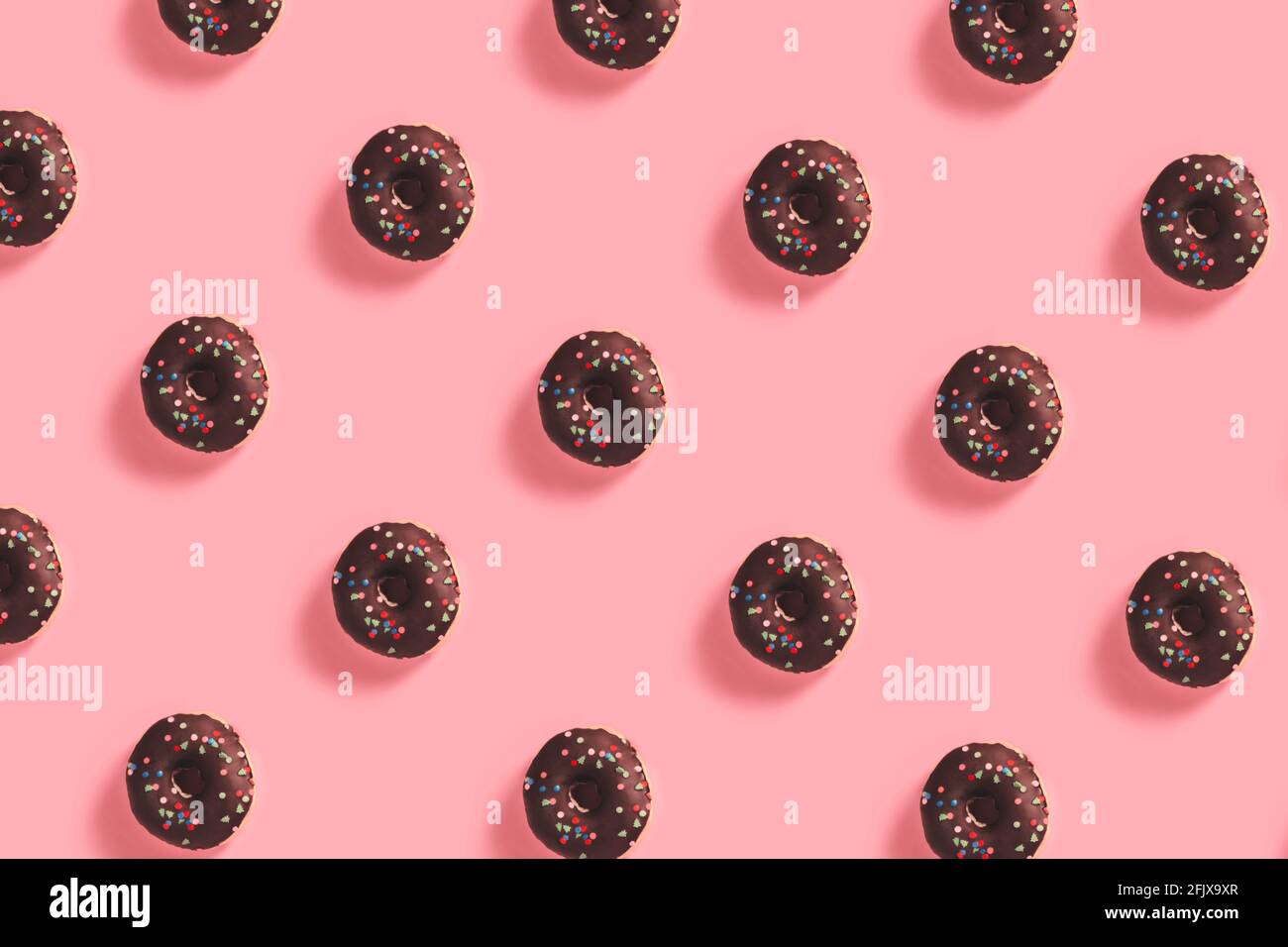 Sweet Chocolate Donut Pattern on Pink Backdrop Stock Photo
