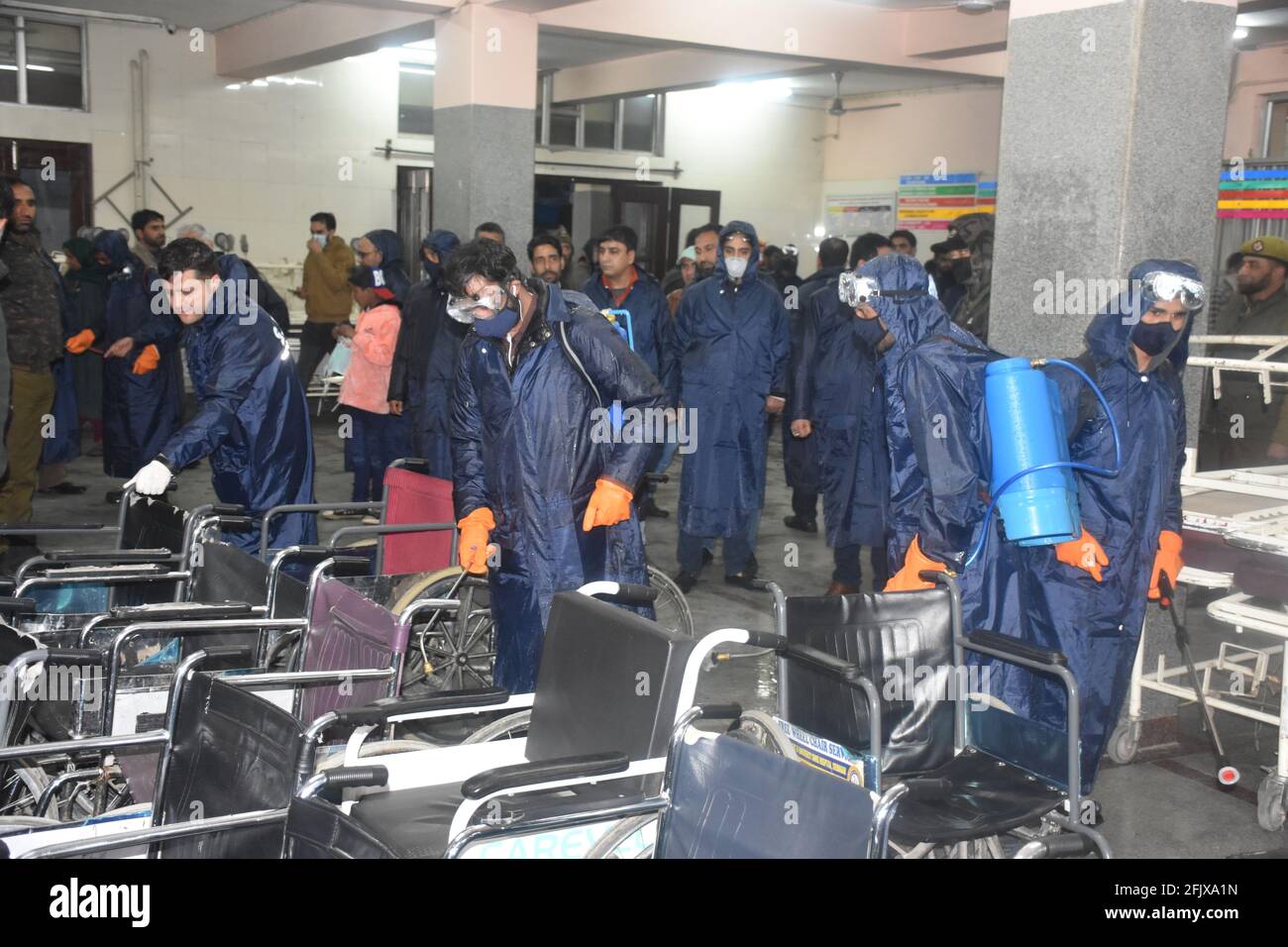 Srinagar, Jammu and kashmir India 07 August 2020. Blue kit wearing men doing fumigation indoor buildings houses complexes hospitals and schools and du Stock Photo