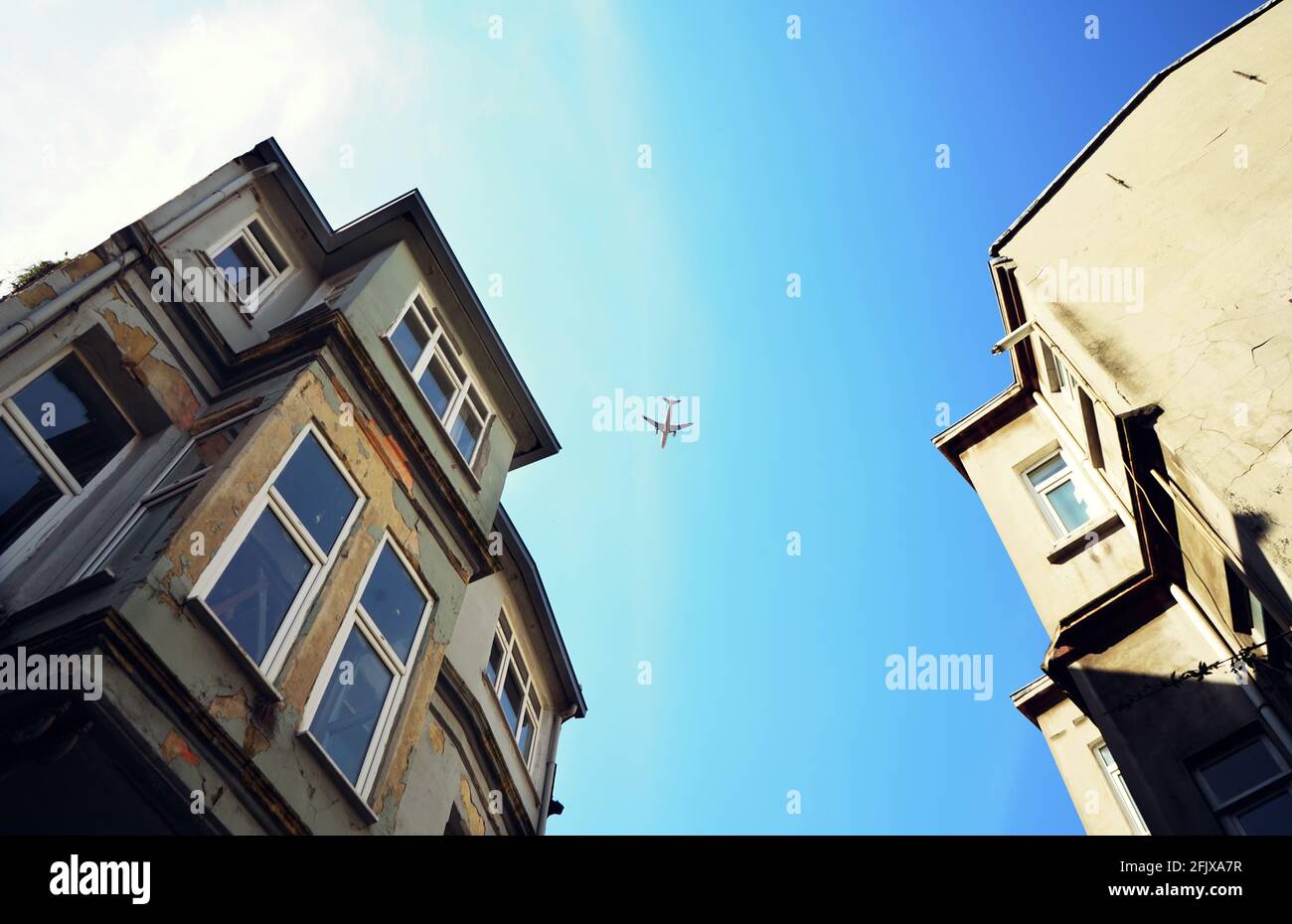 Old buildings and plane above. Stock Photo