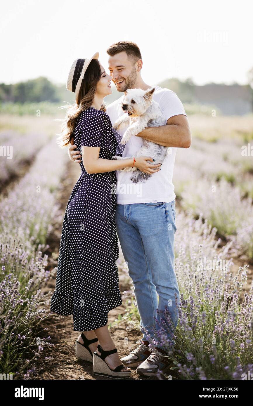 Loving couple with dog in lavender field Stock Photo - Alamy