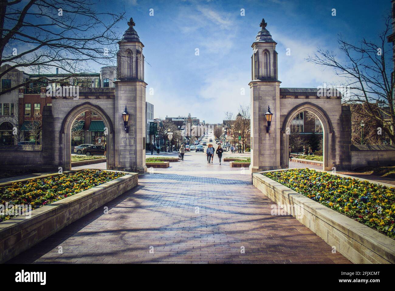03_23_2021 Bloomington USA Sample Gates leading out of Indiana University into downtown with students and a senior lady walking and running and many c Stock Photo