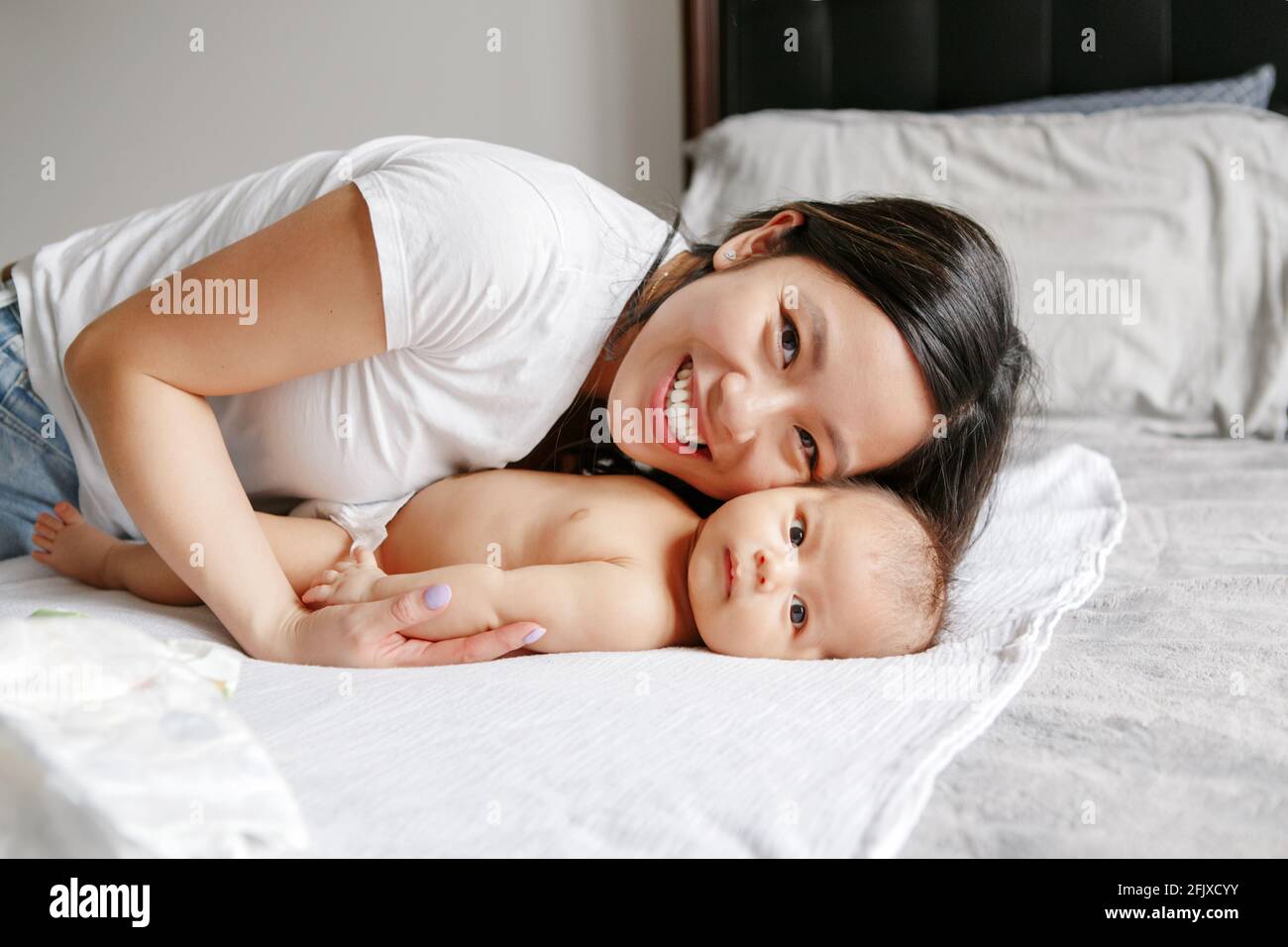 Mothers day holiday. Happy Chinese Asian mother hugging newborn son. Stock Photo
