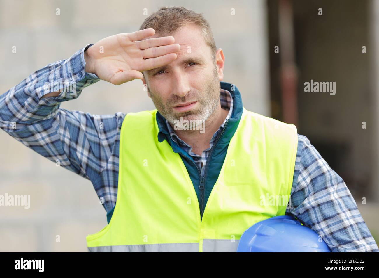 worker wipes the sweat from his forehead Stock Photo