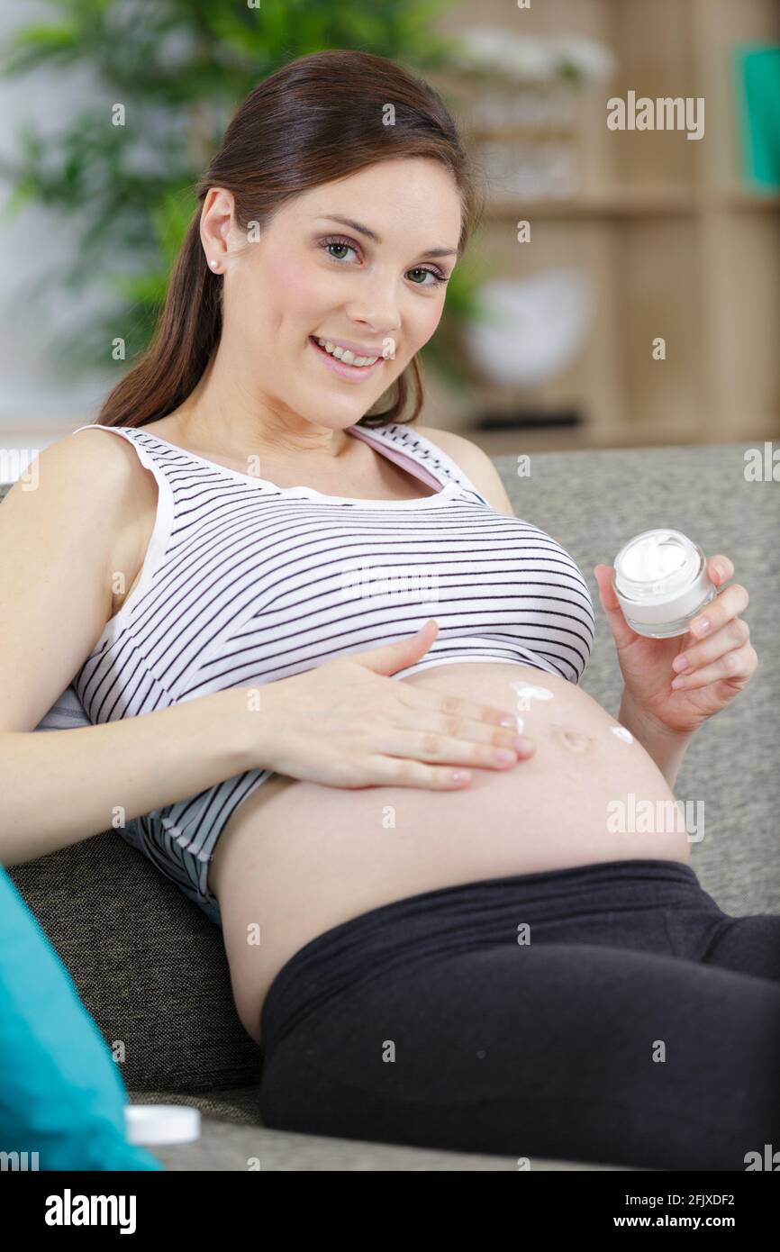 pregnant woman putting cream on her belly Stock Photo Alamy