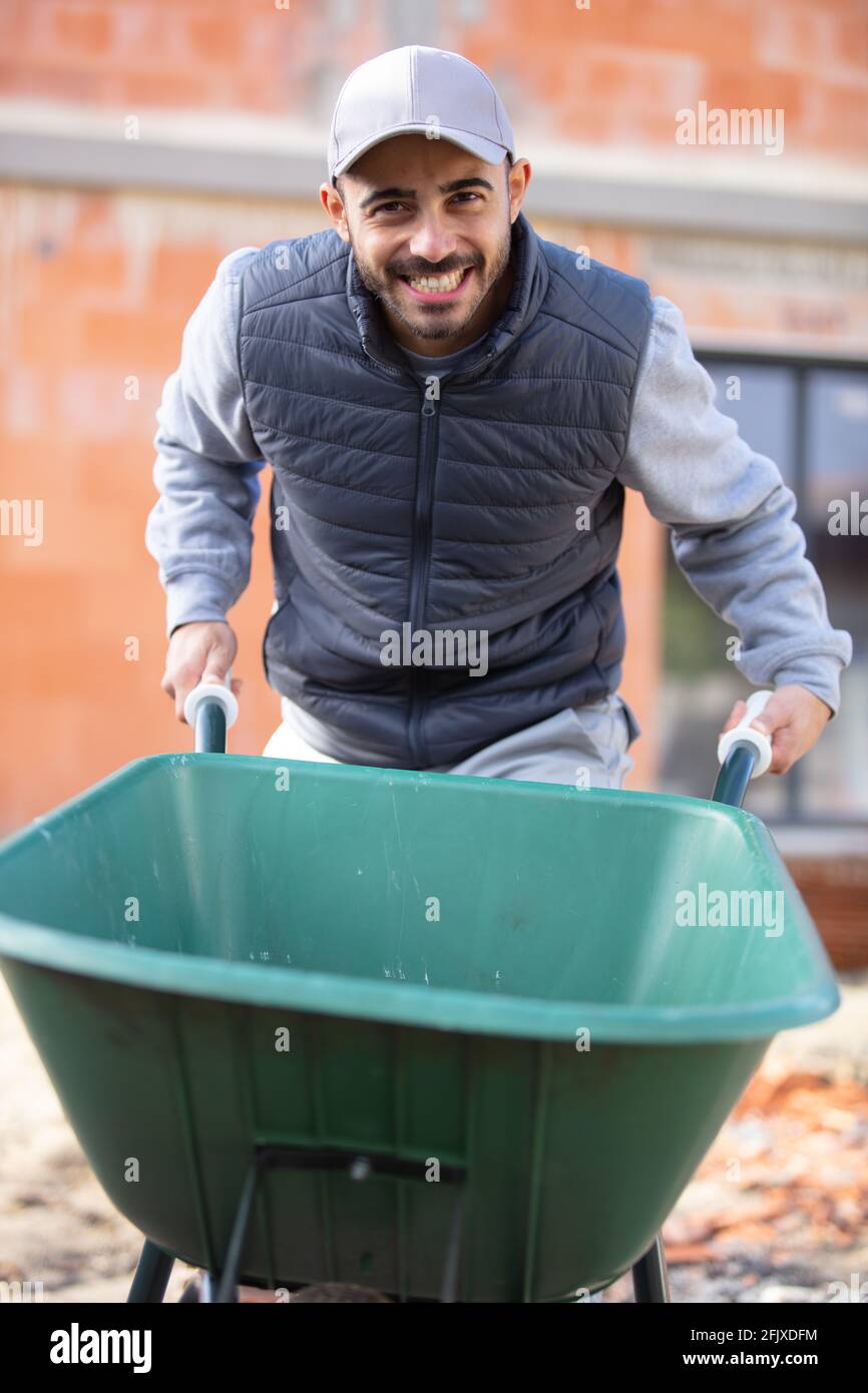 happy male builder with wheelbarrow Stock Photo