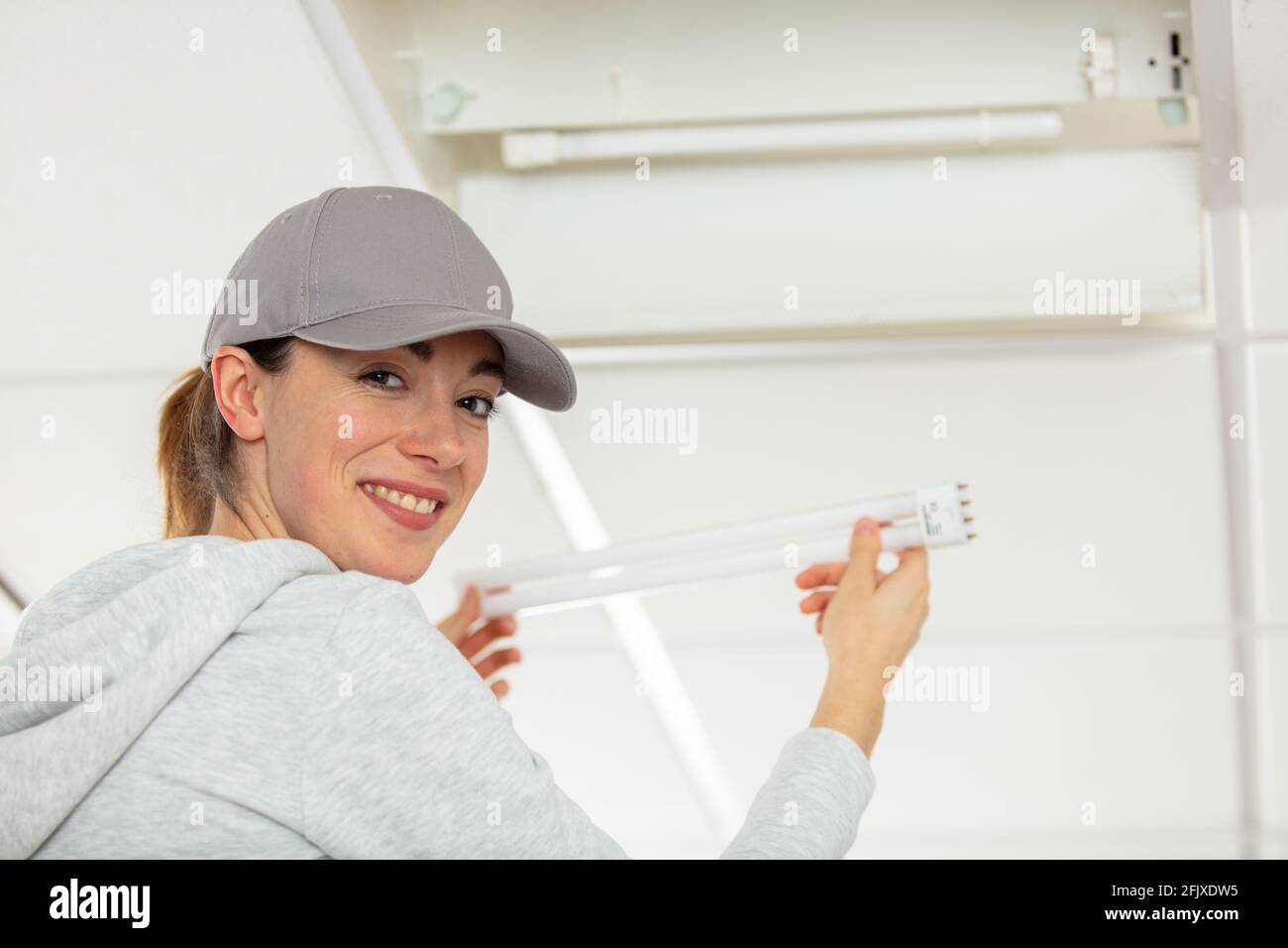 woman installing a replacement fluorescent bulb Stock Photo - Alamy