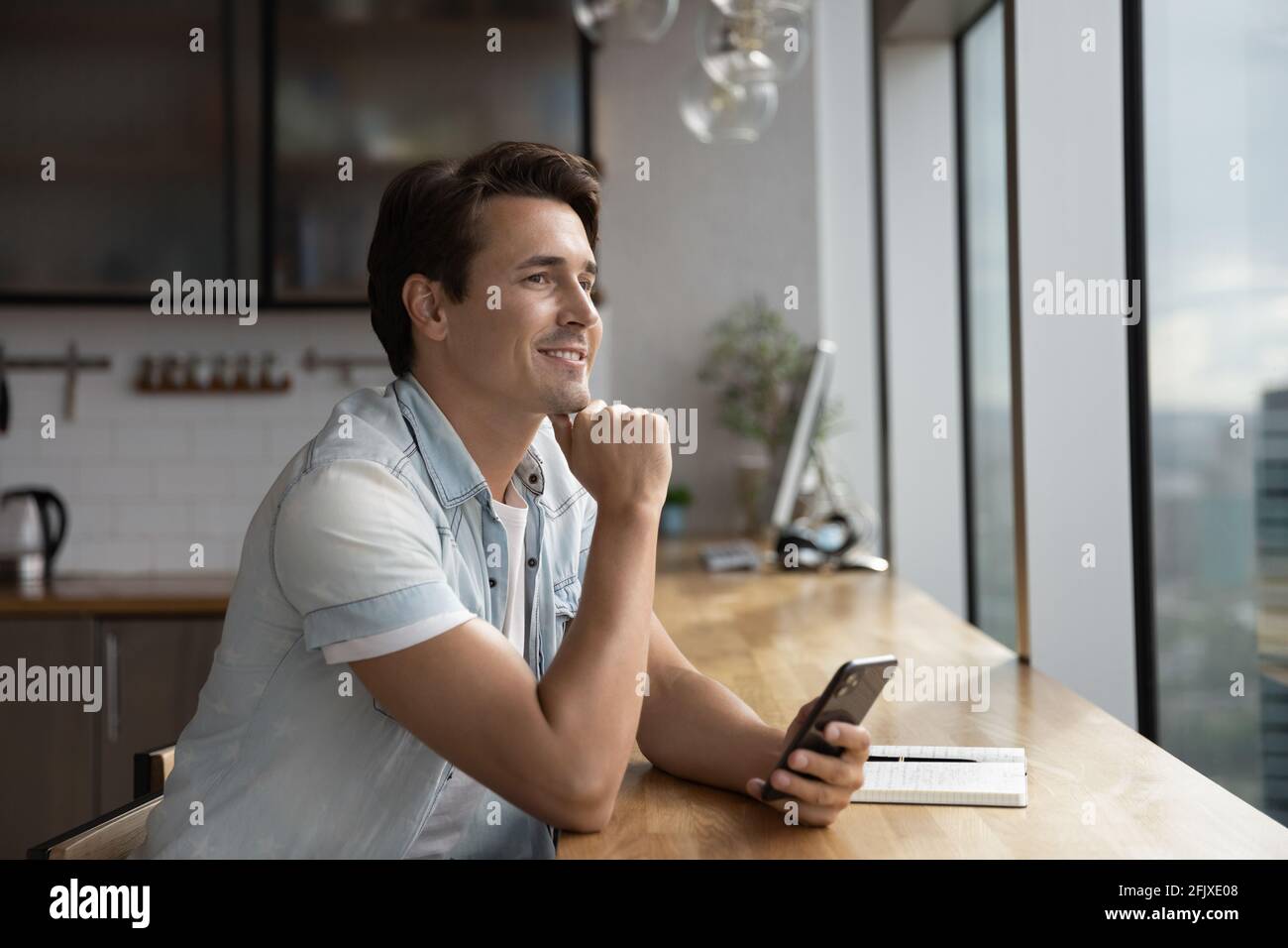 Pensive man use smartphone look in distance thinking Stock Photo
