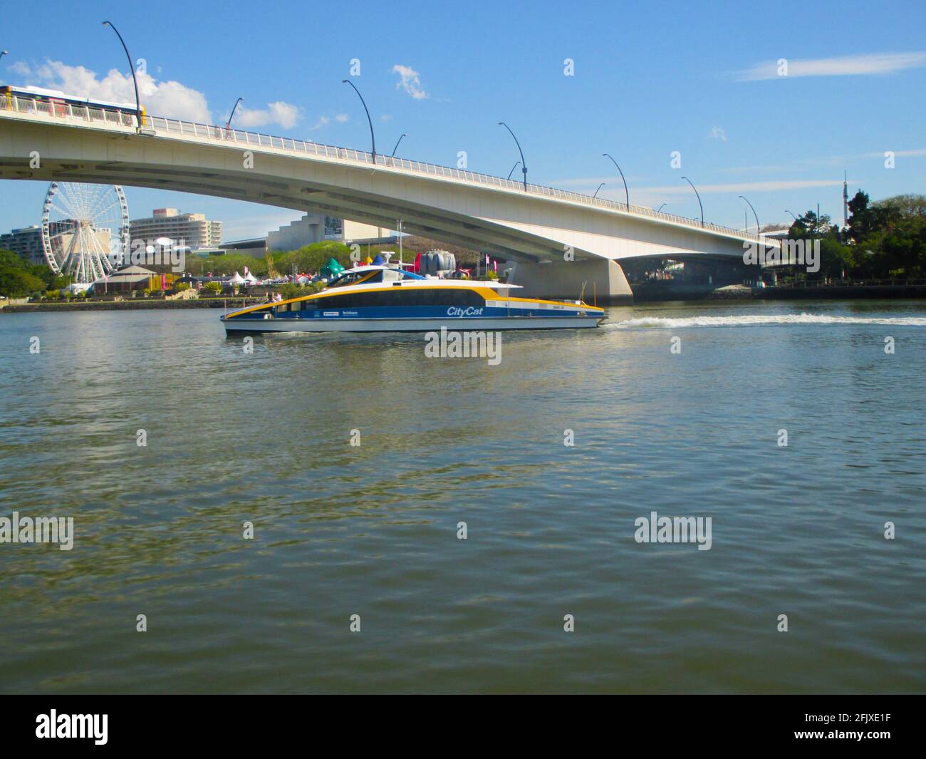 Brisbane Australia circa 2015-CityCat Under Pedestrain Bridge With Wheel of Brisbane in Background Stock Photo
