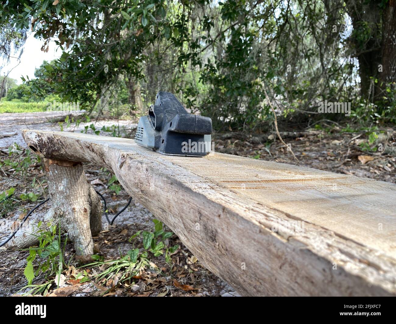 Sanding machine being used to sand down a handmade wooden bench for an