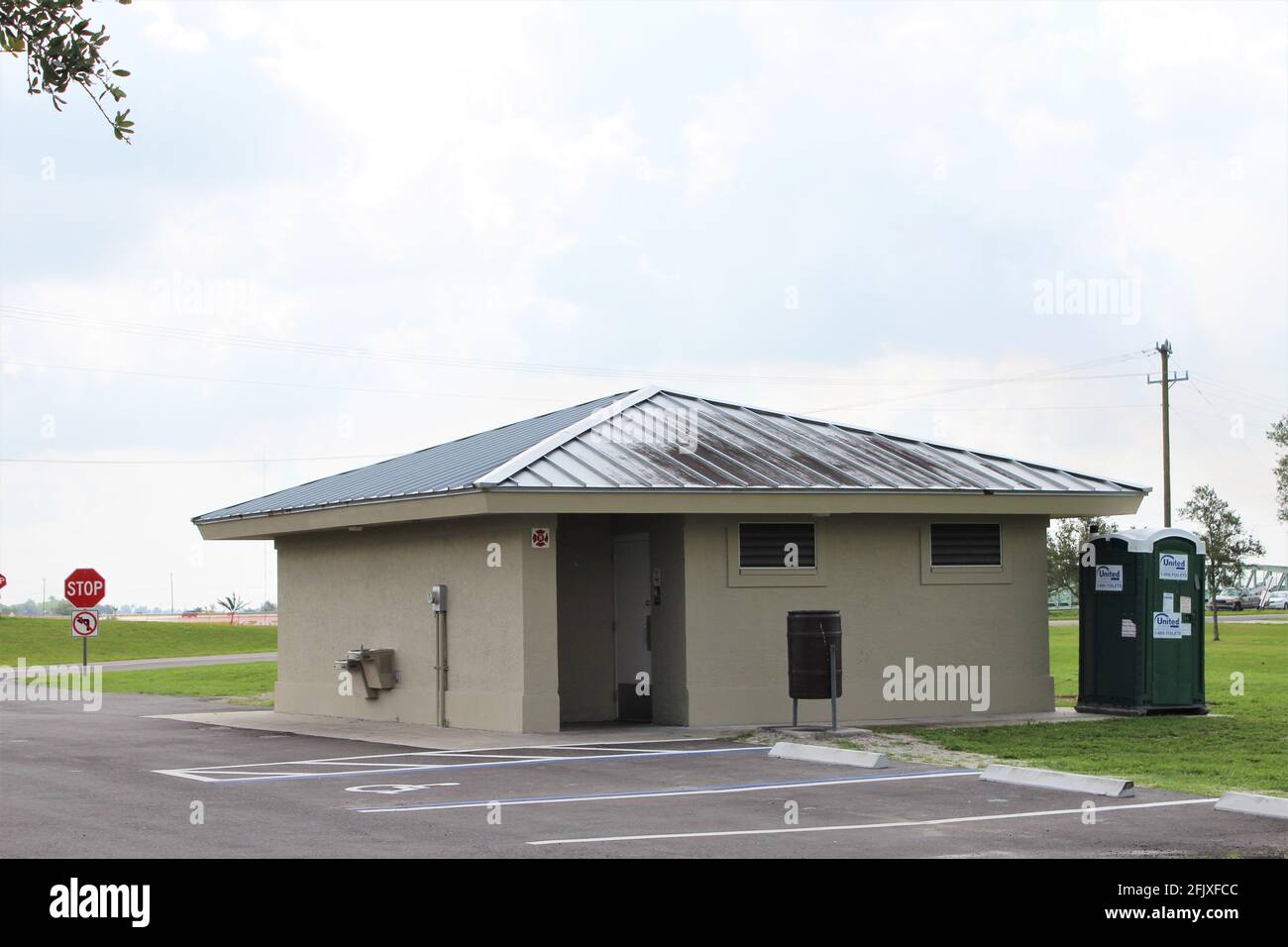 Public bathroom site at John Stretch Memorial Park with a United Site Portable Toilet Rental outside for construction site workers. Near lake Okeechobee Stock Photo