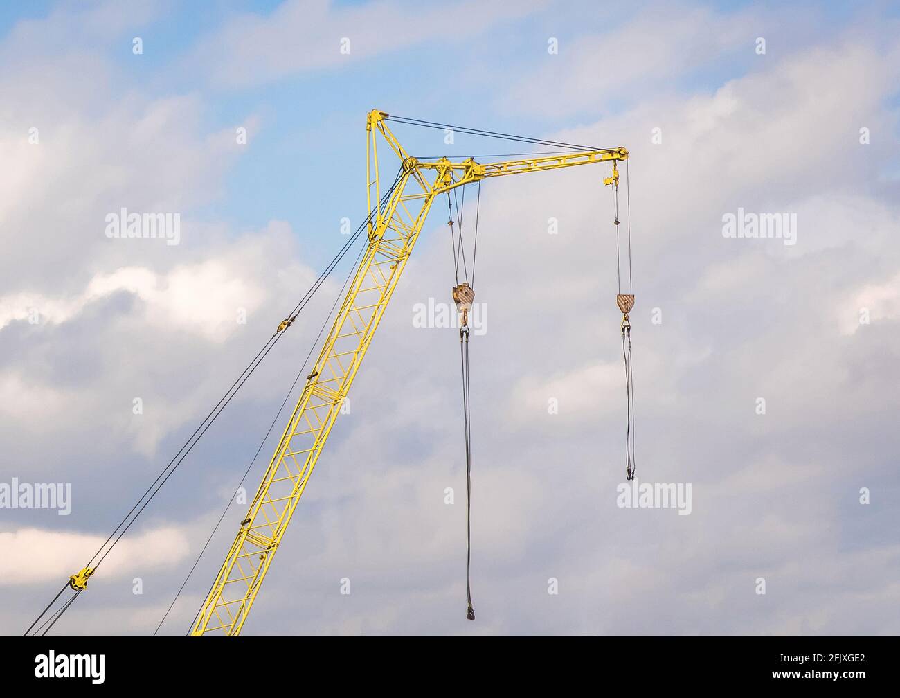 Machine industrial construction crane against the sky with clouds. Stock Photo