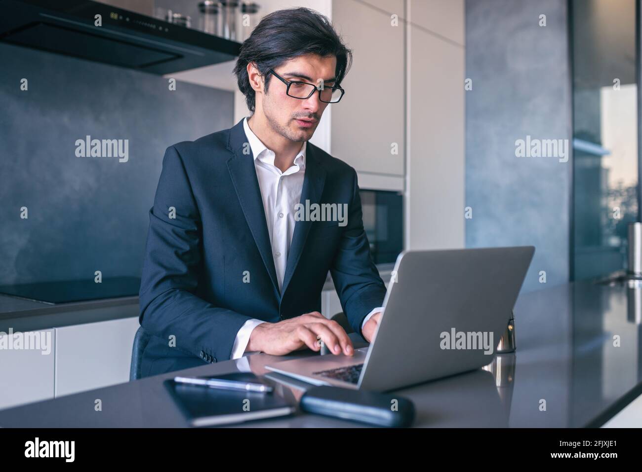 Elegant businessman works from home with a laptop. Teleworking concept Stock Photo
