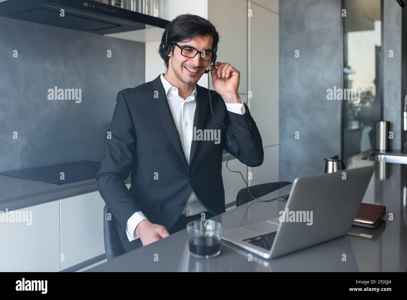 Businessman with headset at a video conference from his home computer Stock Photo