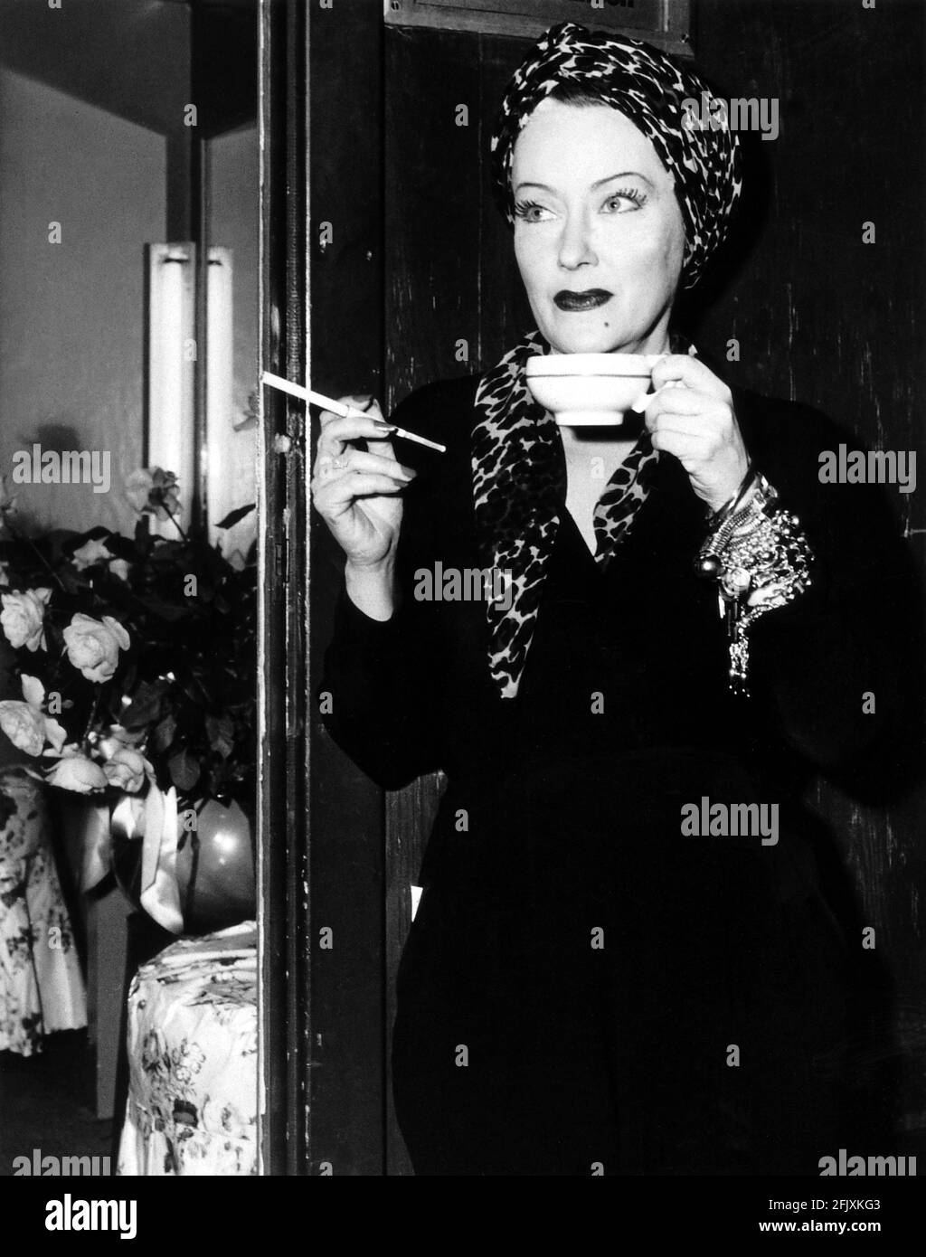 1951 , USA : The movie actress   GLORIA SWANSON ( 1898 - 1983 )  as Norma Desmond in SUNSET BOULEVARD ( Viale del Tramonto ) by Billy Wilder, costume by Edith HEAD , Paramount pubblicity still - FILM - CINEMA - attrice cinematografica - leopardo - leopardato - maculato - VAMP - leopard - leopard-skin - leoparded - hat - turbante - turban - VAMP - DIVA - DIVINA - DIVINE - Hollywood on Hollywood  - bracelet - braccialetto - gioielli - gioiello - jewel - jewels - jewellery - bijoux - bigiotteria - mole - neo - cup of the - tazza di té -  sigaretta - cigarette - fumo - fumatore - fumatrice - smoke Stock Photo