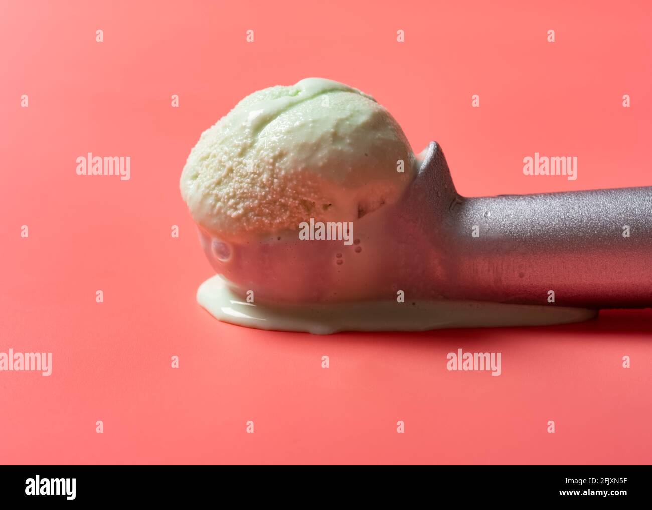 side view spoon with hami melon flavor ice cream starts melting on a