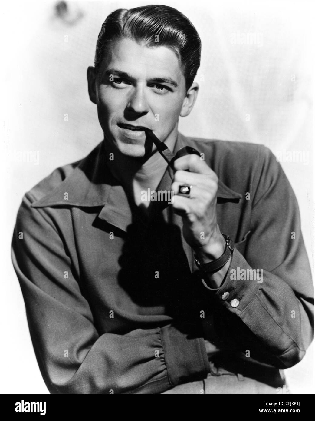 1949 ca.  , Los Angeles , USA : The future USA President , the movie actor RONALD REAGAN ( 1911 - 2004  )  , pubblicity studio still - ATTORE - CINEMA - pipa - pipe - fumatore - smoker - smoke - fumo - personalità celebrità attori che fumano - attore che fuma -  celebrity celebrities personality personalities actors smokers - orologio da polso - swatch - colletto - collar  ----  Archivio GBB Stock Photo