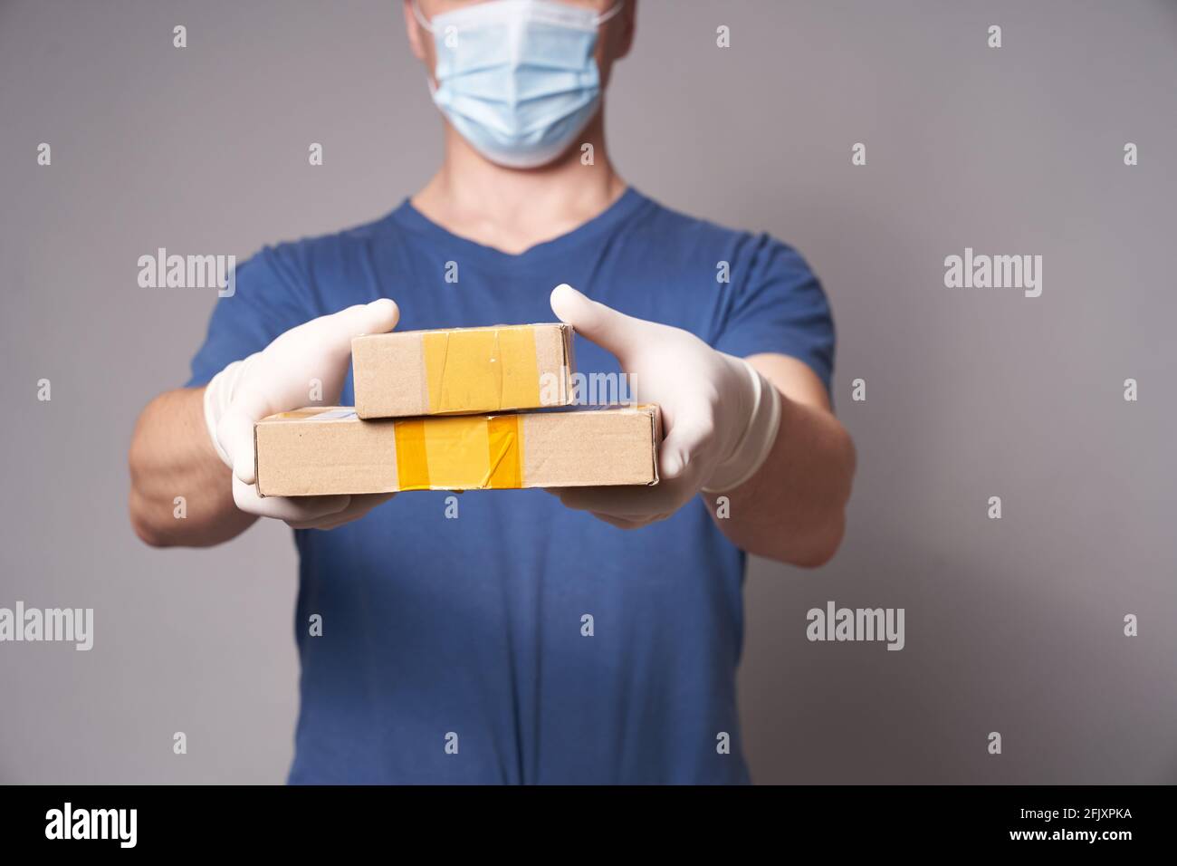 Delivery Man Wearing Protective Mask And Rubber Gloves Stock Photo