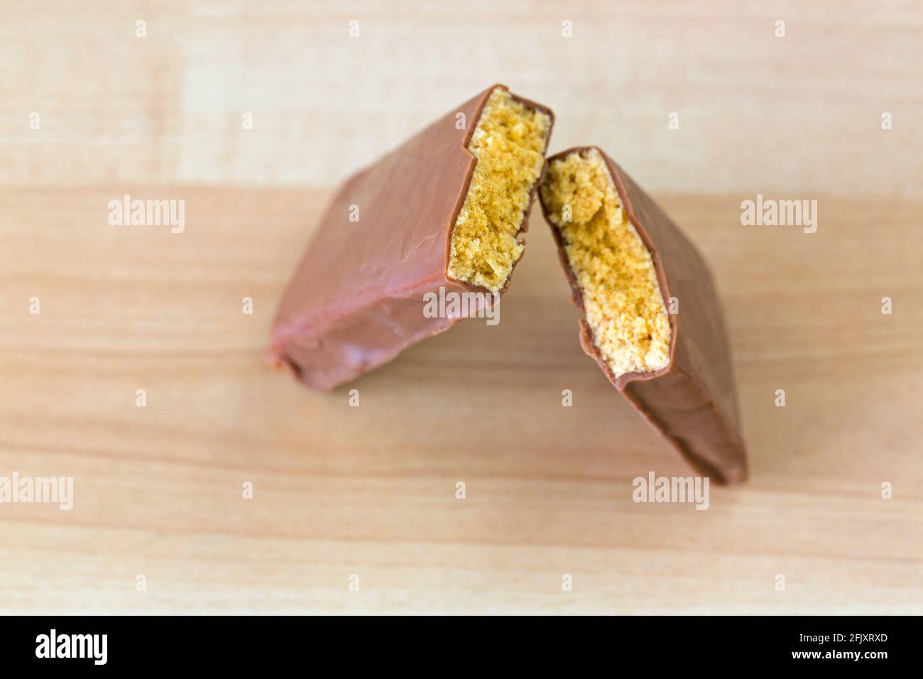 Chocolate coated peanut butter Energy bar with protein blend, amino acids broke into half on wooden background Stock Photo