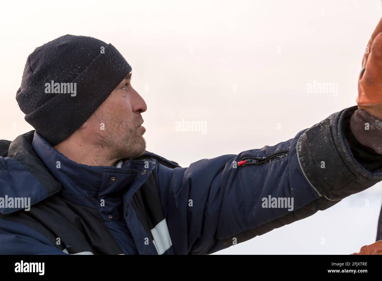 Portrait of a fitter in a blue jacket with a hood and a black knitted ...