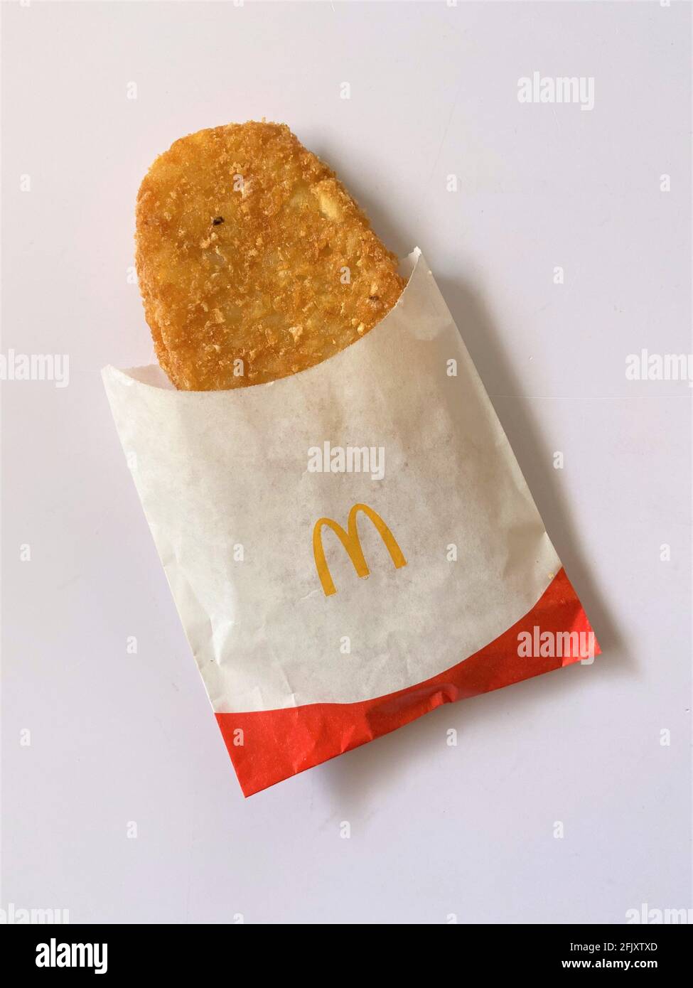 Warm freshly fried hash brown for breakfast from McDonalds fast food restaurant. Stock Photo