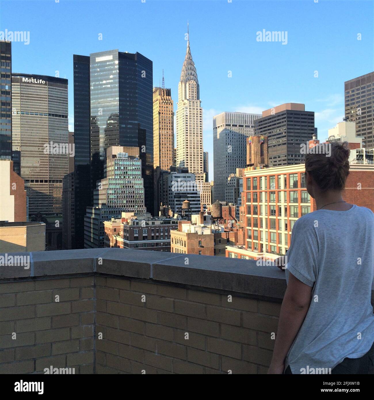 Woman standing on a Manhattan New York City roof top apartment building