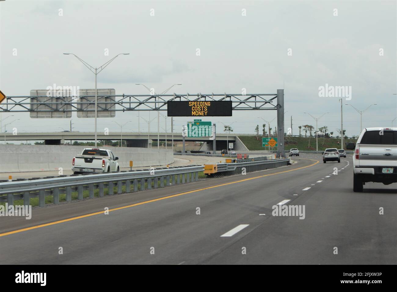 Driving through I-75 expressway on a cloudy day. Caution signs for speeding displayed. Stock Photo