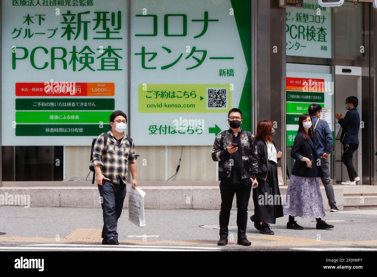 Tokyo, Japan. 25th Apr, 2021. Pedestrians passing by a polymerase chain reaction (PCR) testing center for the new COVID-19 run by a clinic in Shinbashi, Tokyo. Facing criticism as COVID-19 continues to rise across Japan, Prime Minister Yoshihide Suga, took another hit on Sunday after his Liberal Democratic Party lost the first national elections since he took office. (Photo by James Matsumoto/SOPA Images/Sipa USA) Credit: Sipa USA/Alamy Live News Stock Photo