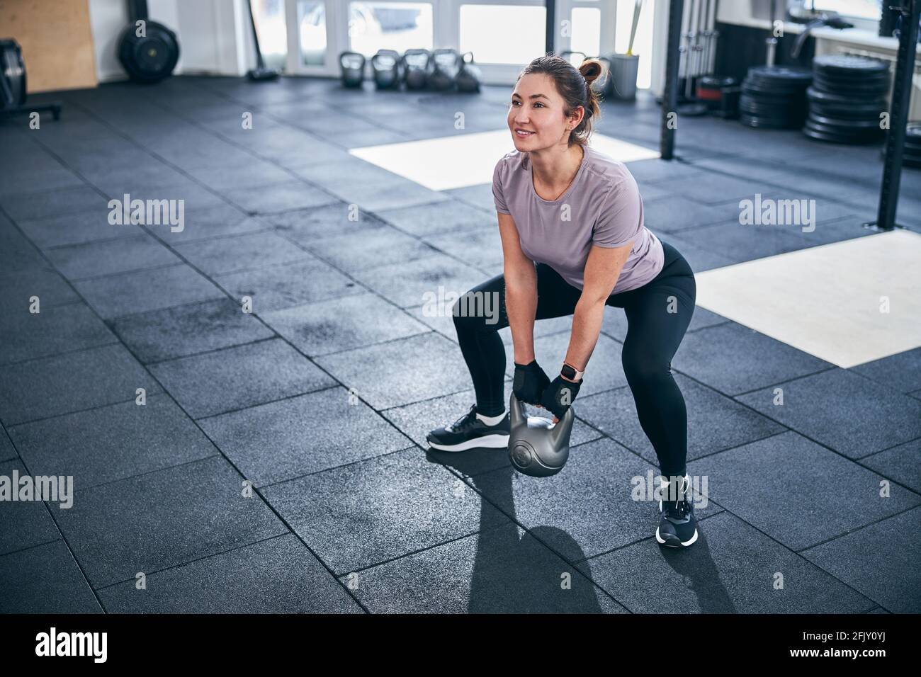 Dark-haired young woman performing a strength exercise Stock Photo