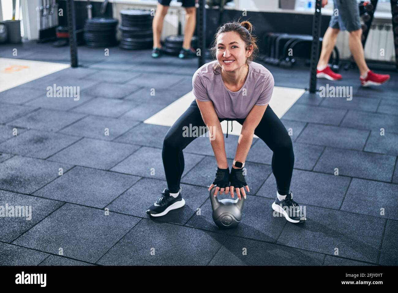 Joyous athlete posing for the camera during the weight-lifting workout Stock Photo